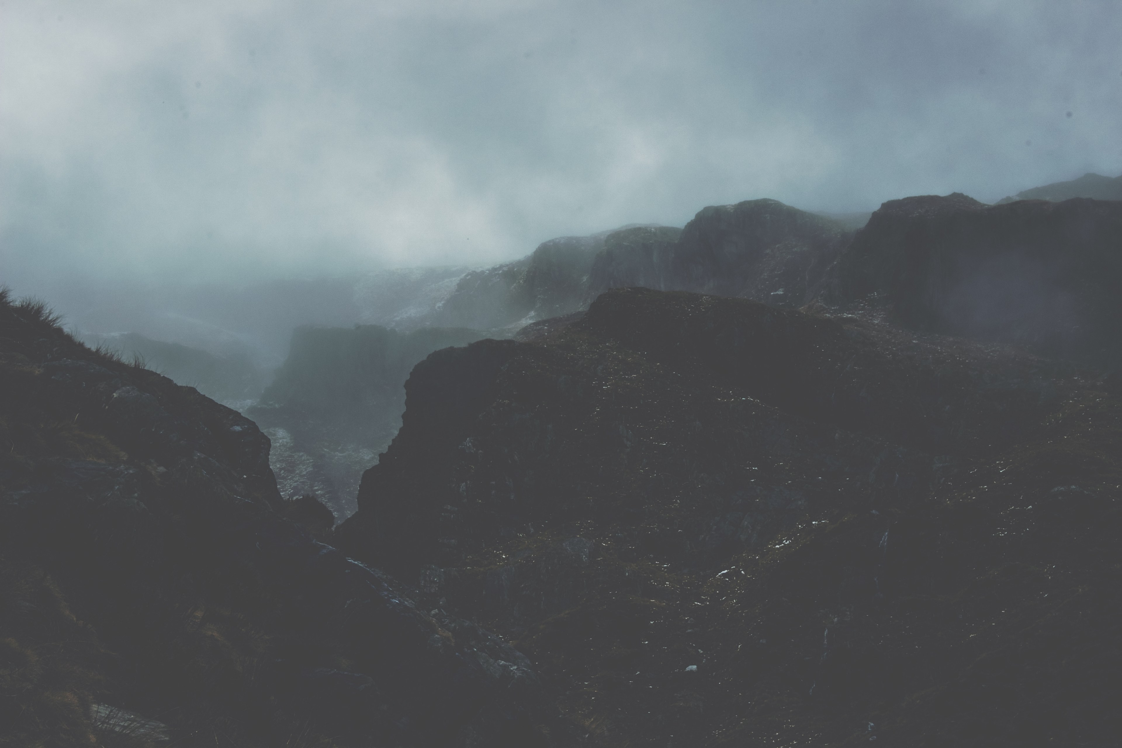fog rolls in over dark stone mountains in mount aspiring national park, overcast mountains 4k, HD Wallpaper