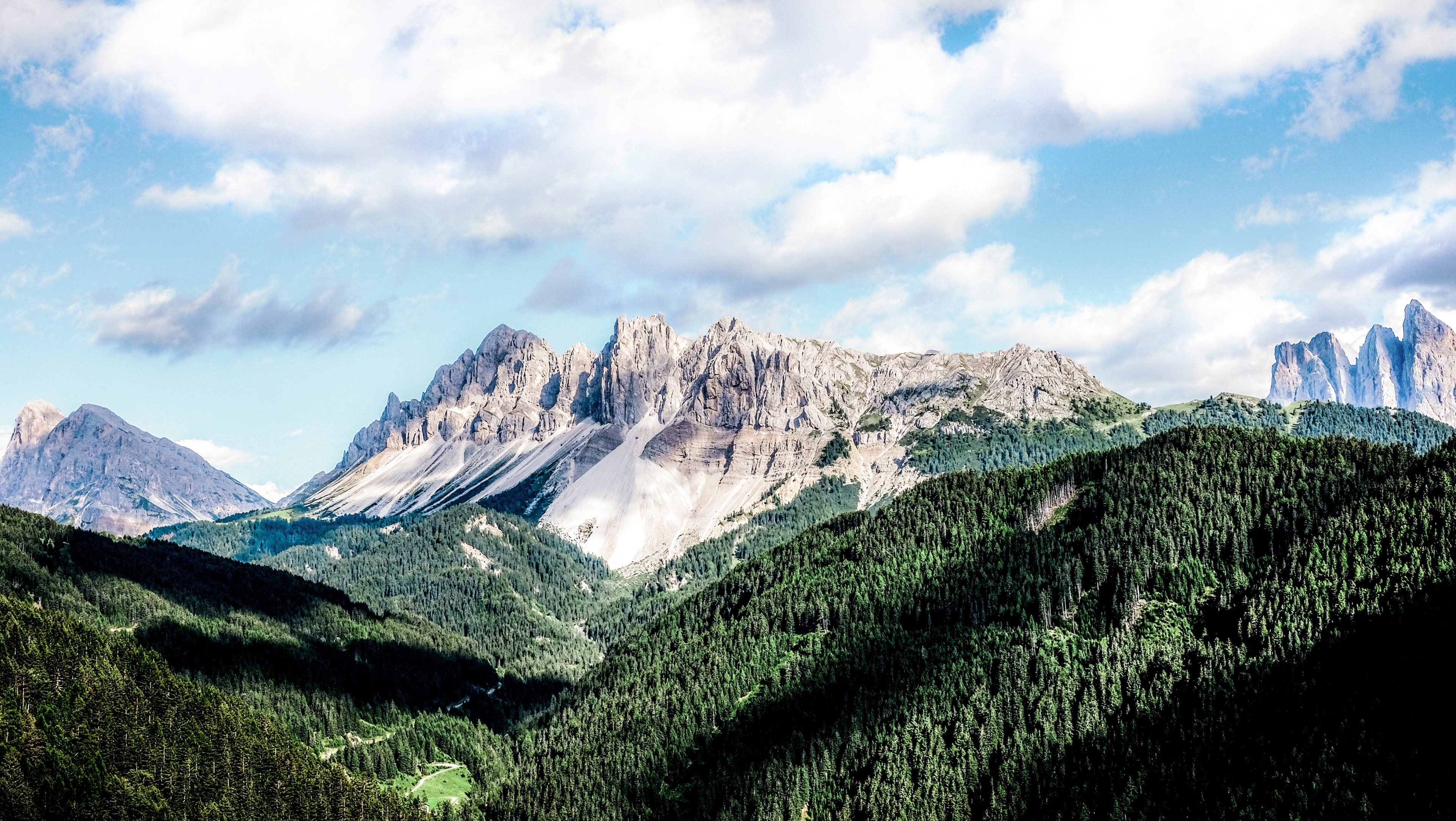 a mountain ridge with jagged peaks towering over a wooded valley in san martino in badia, jagged peaks over a valley 4k, HD Wallpaper