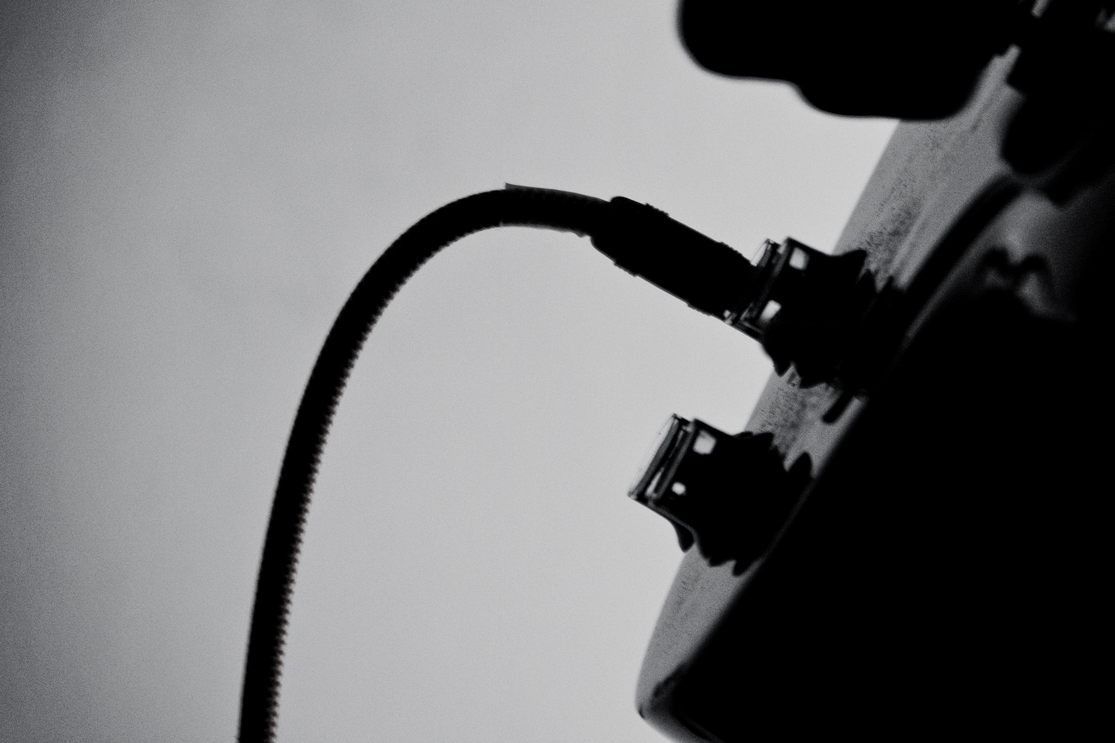 a black and white shot of a wire plugged in into a guitar, guitar wire in black and white 4k, HD Wallpaper