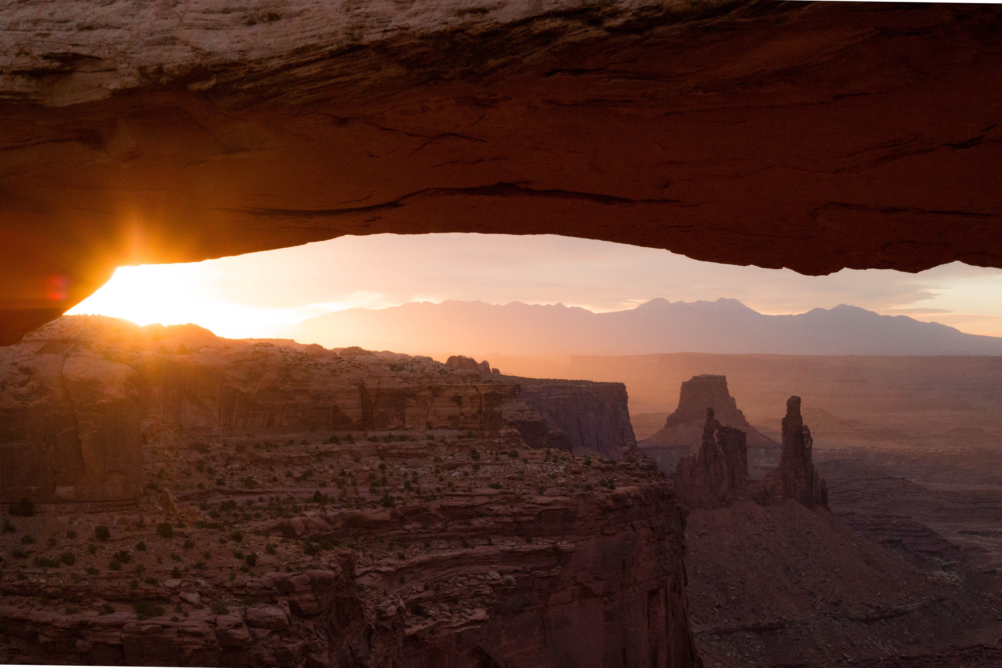 view from under a rock arch on the vast sandstone canyon in canyonlands national park, caught a beautiful sunrise at the canyon lands 4k, HD Wallpaper