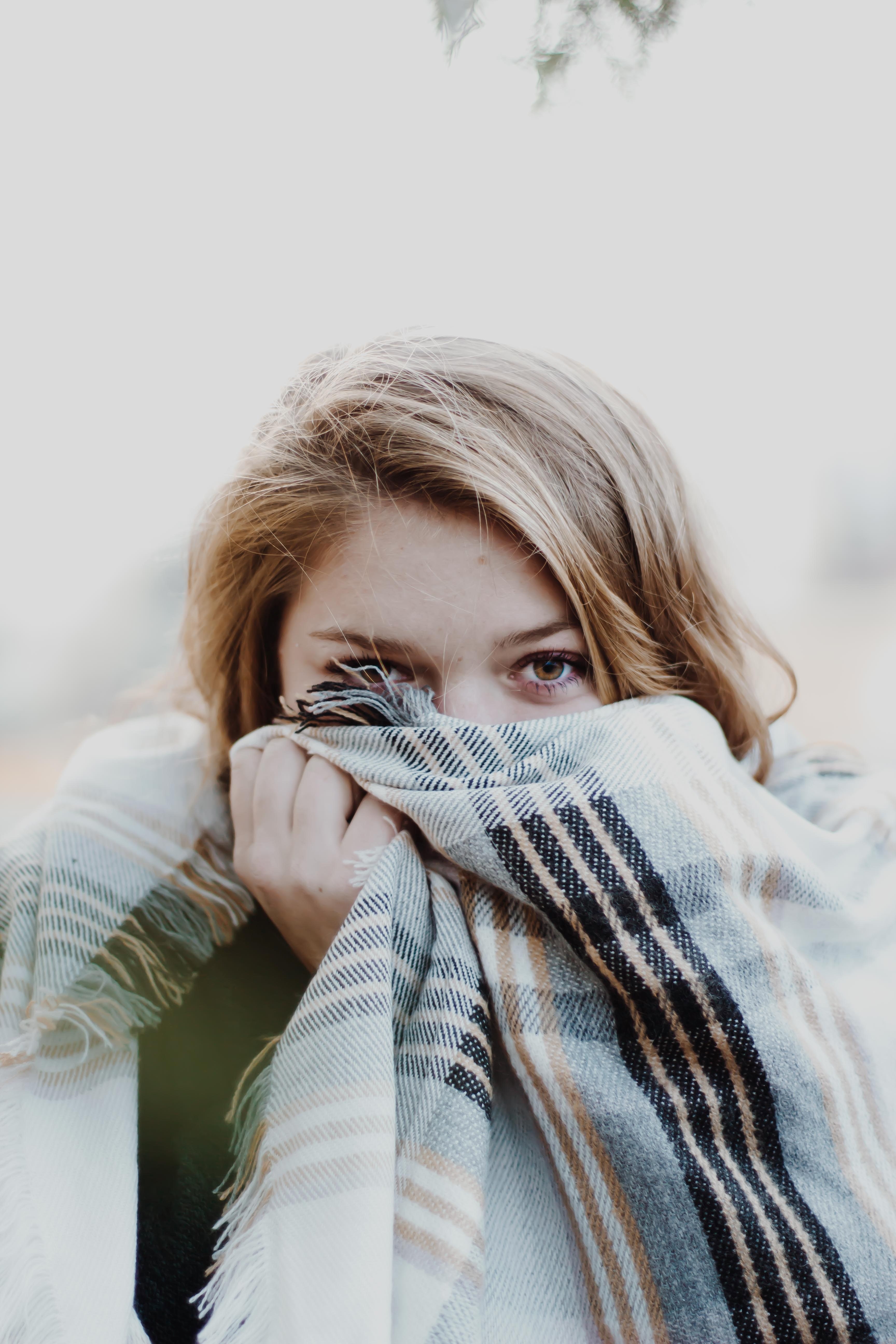 a young blonde woman hiding her face behind a blanket, lost in the wilderness 4k, Phone HD Wallpaper