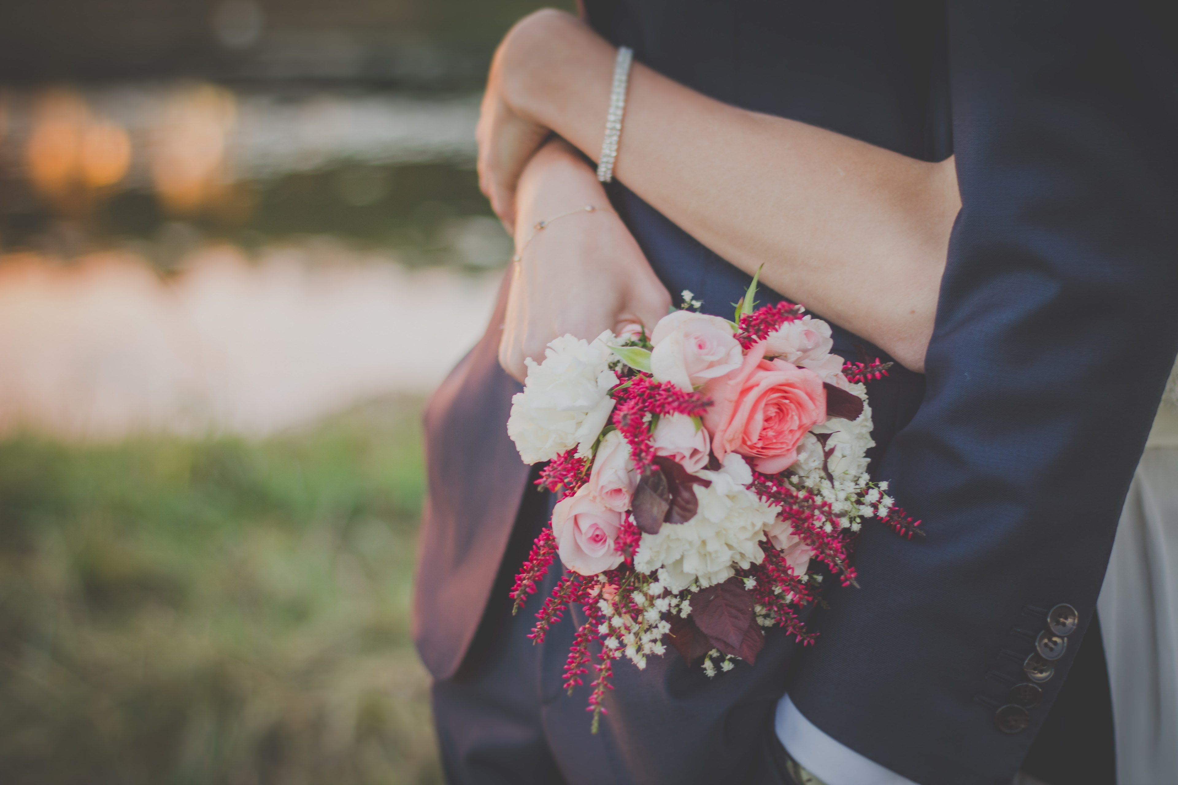 bride holds a wedding bouquet of roses while wrapping arms around her groom, wedding day hug 4k, HD Wallpaper