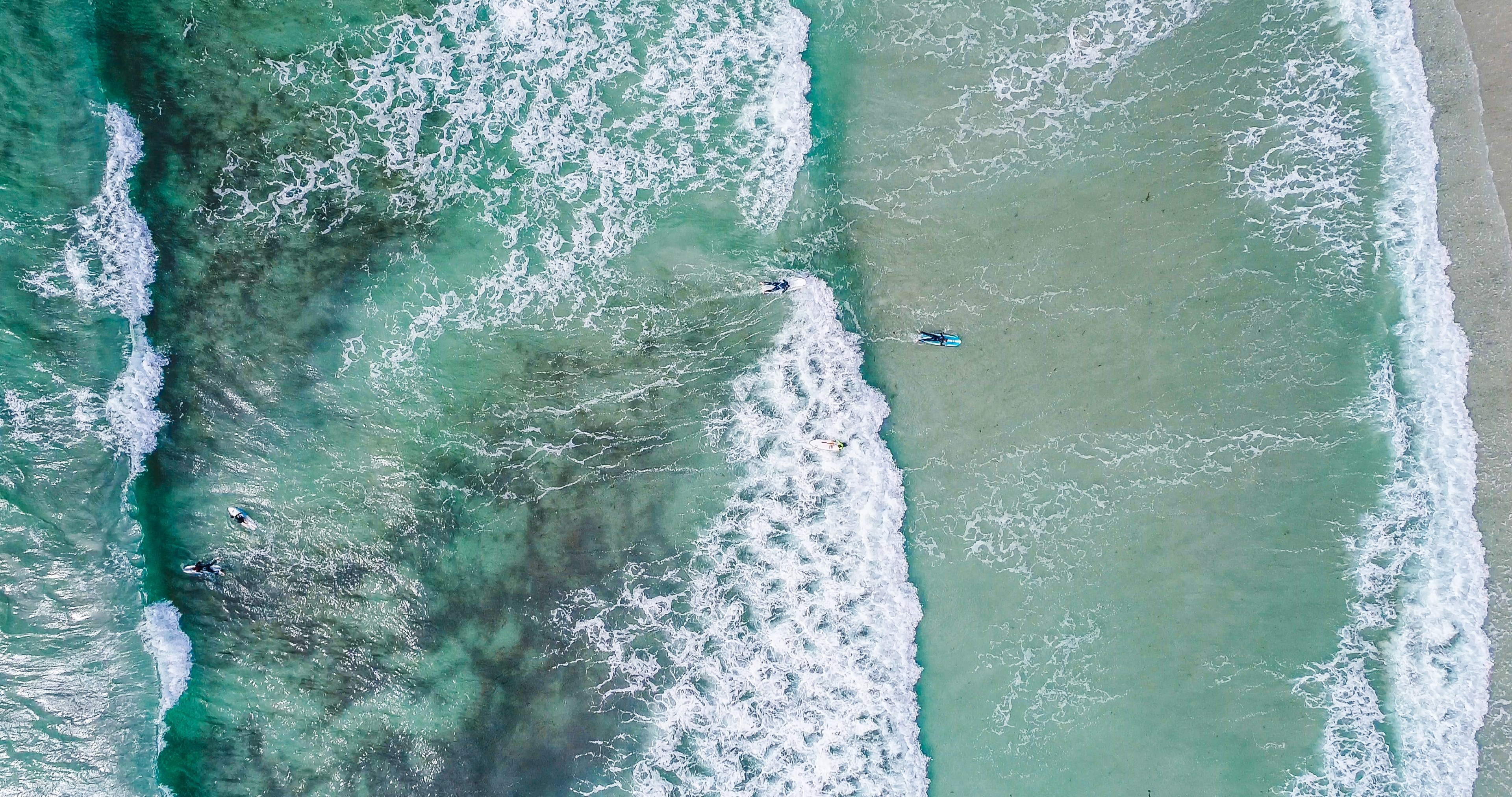 drone aerial view of surfers in the ocean at guernsey surf school, vazon beach surfing 4k, HD Wallpaper