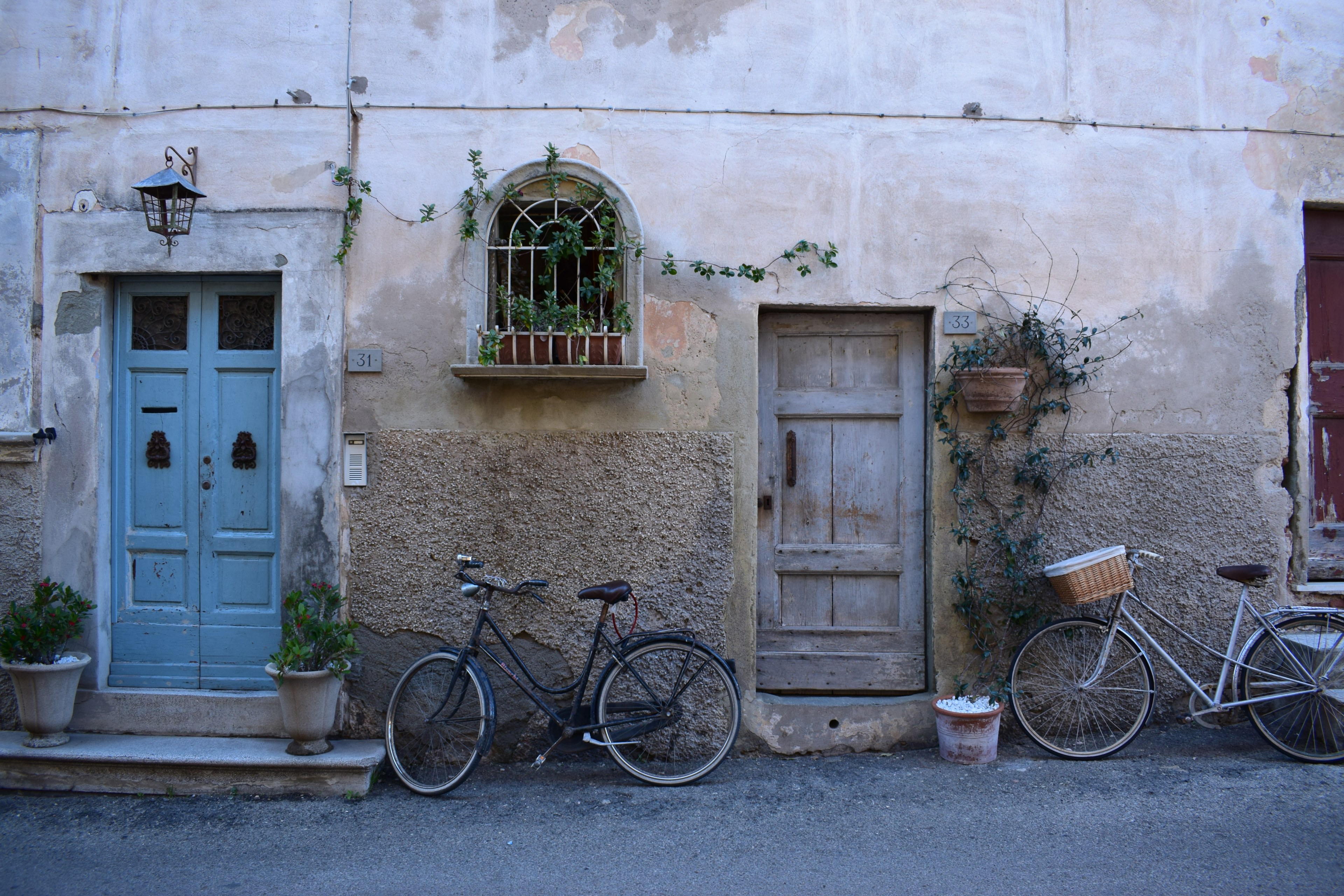 two bicycles parked near wooden doors in an old building facade, wall 4k, HD Wallpaper