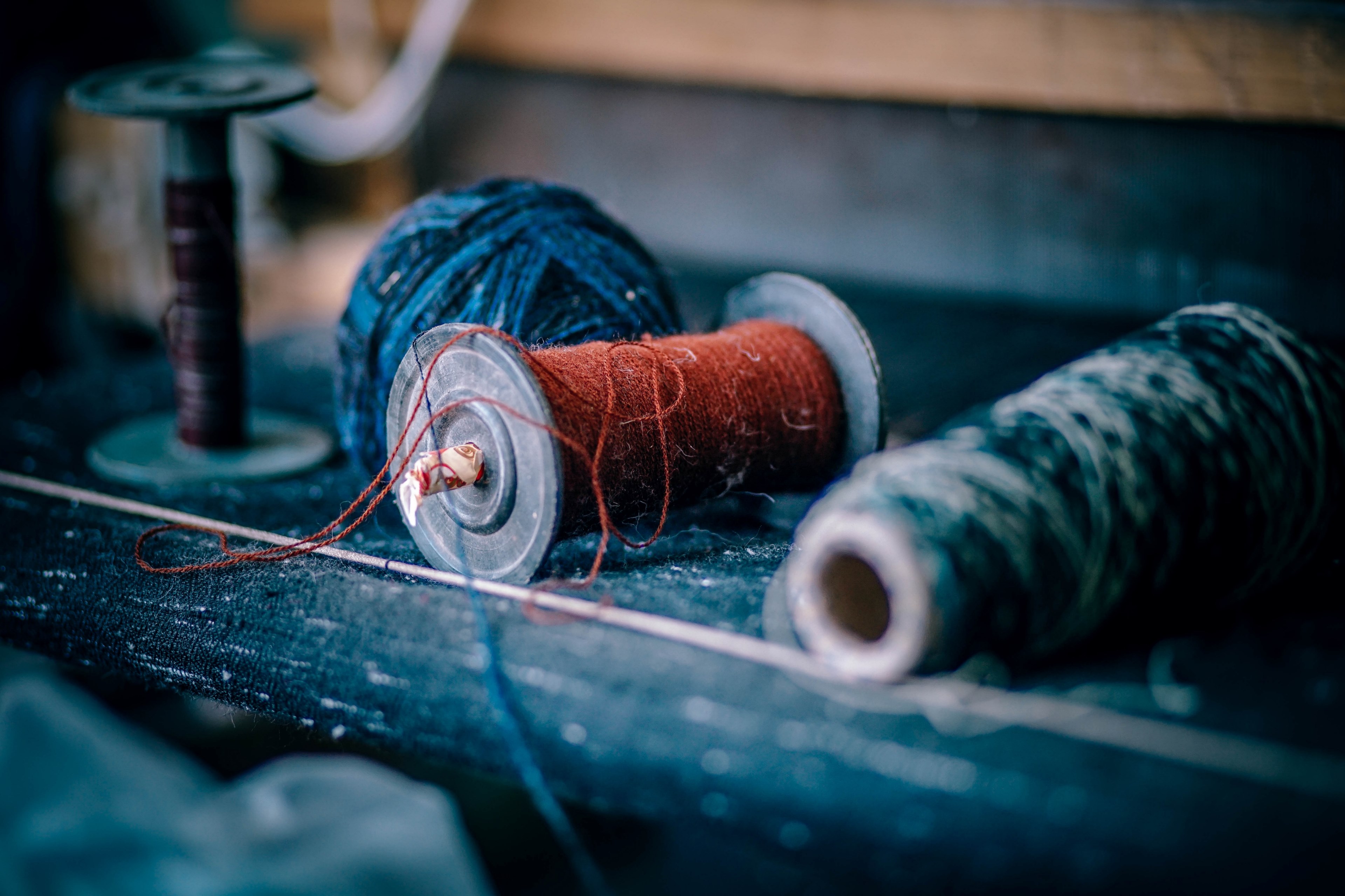a spindle and sewing threads slightly loose on a table in old manali, _red thread 4k, HD Wallpaper