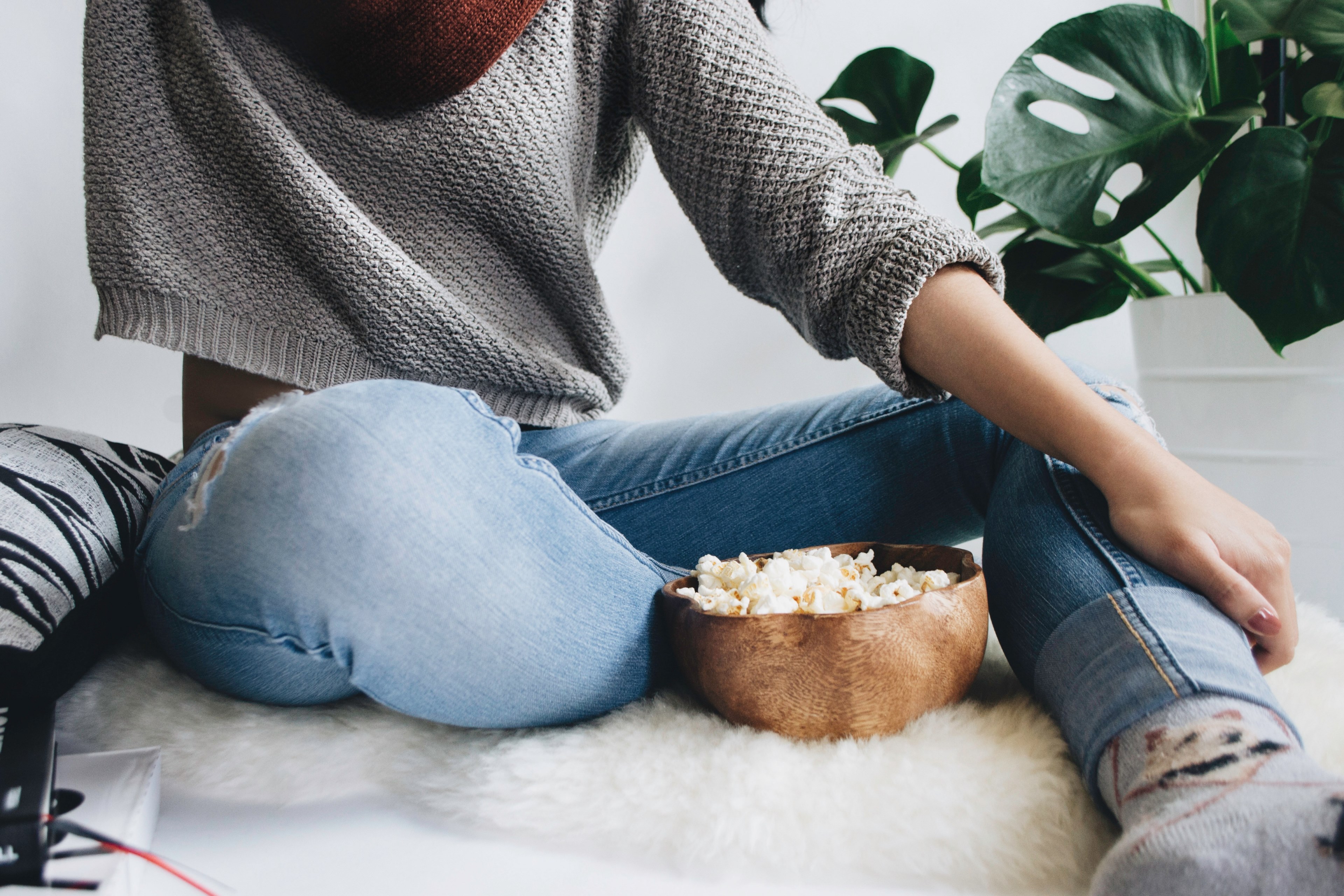 woman in a cropped gray sweater sits on a furry rug with a bowl of popcorn, textures unfolded 4k, HD Wallpaper