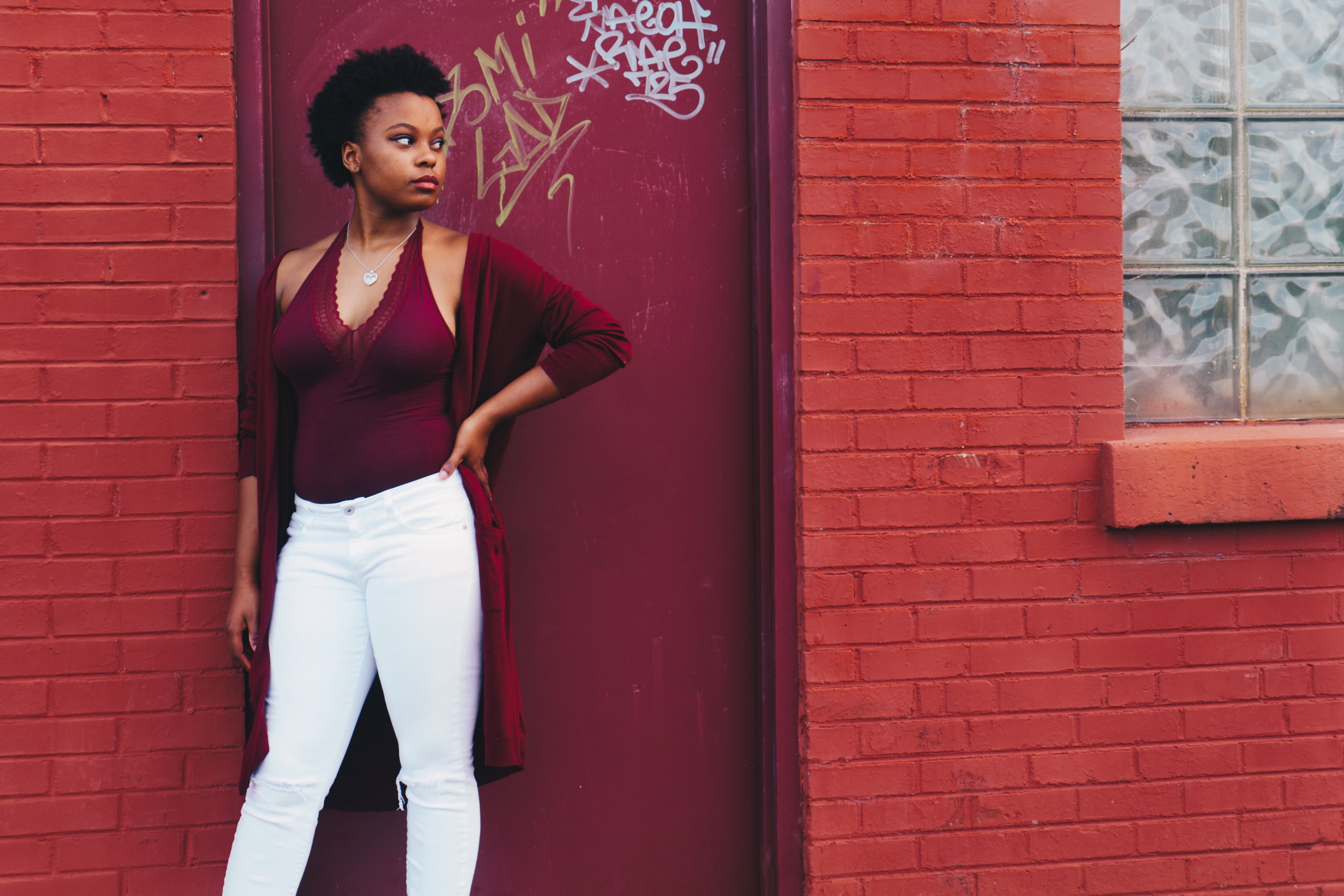 a woman in a red top looks to the side in front of a red wall, woman with red top and wall 4k, HD Wallpaper