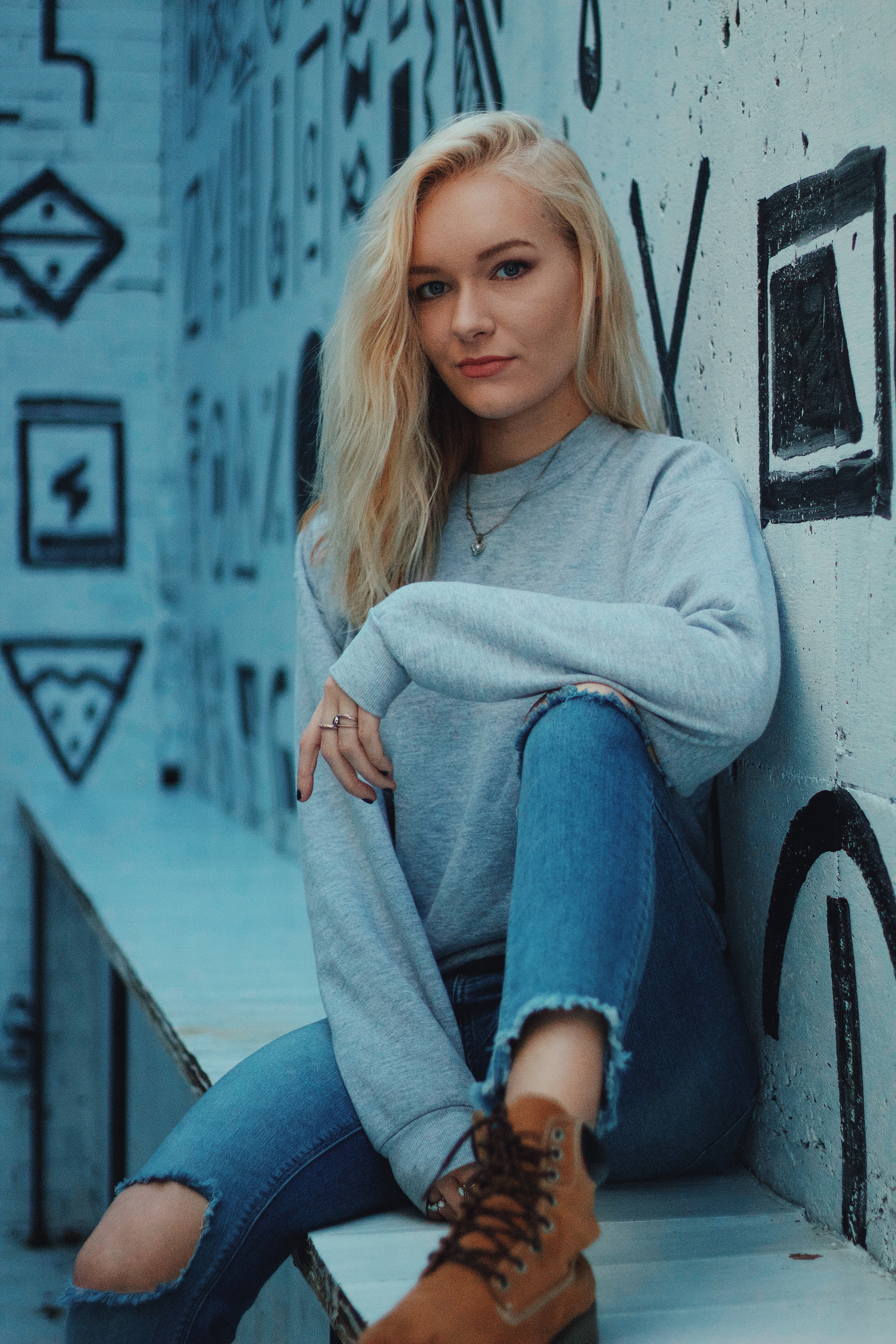 content woman sitting on a bench near a mural with geometric shapes, sitting by a mural 4k, Phone HD Wallpaper