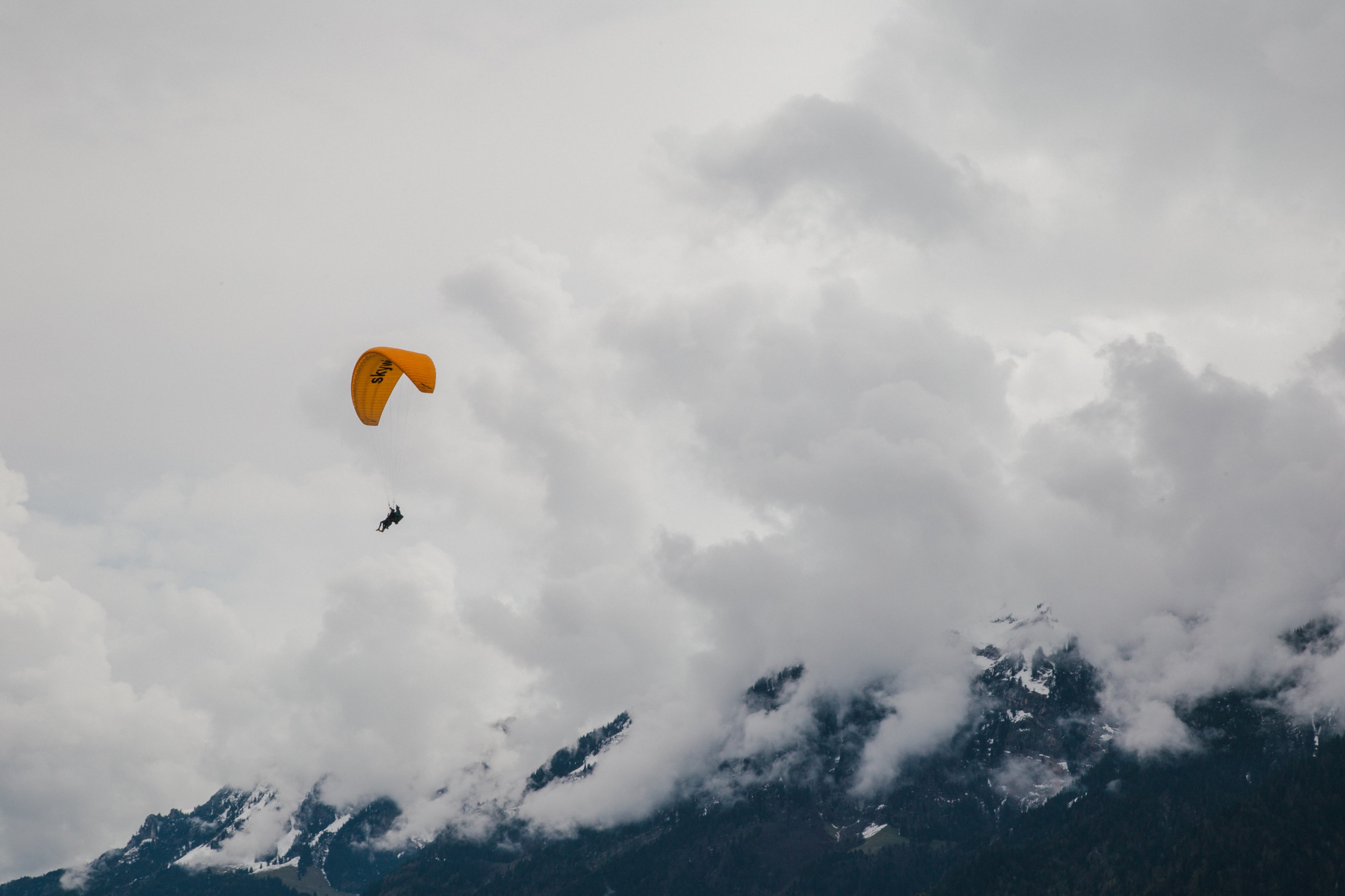 person with a yellow parachute paragliding in the clouds, paragliding interlaken switzerland 4k, HD Wallpaper