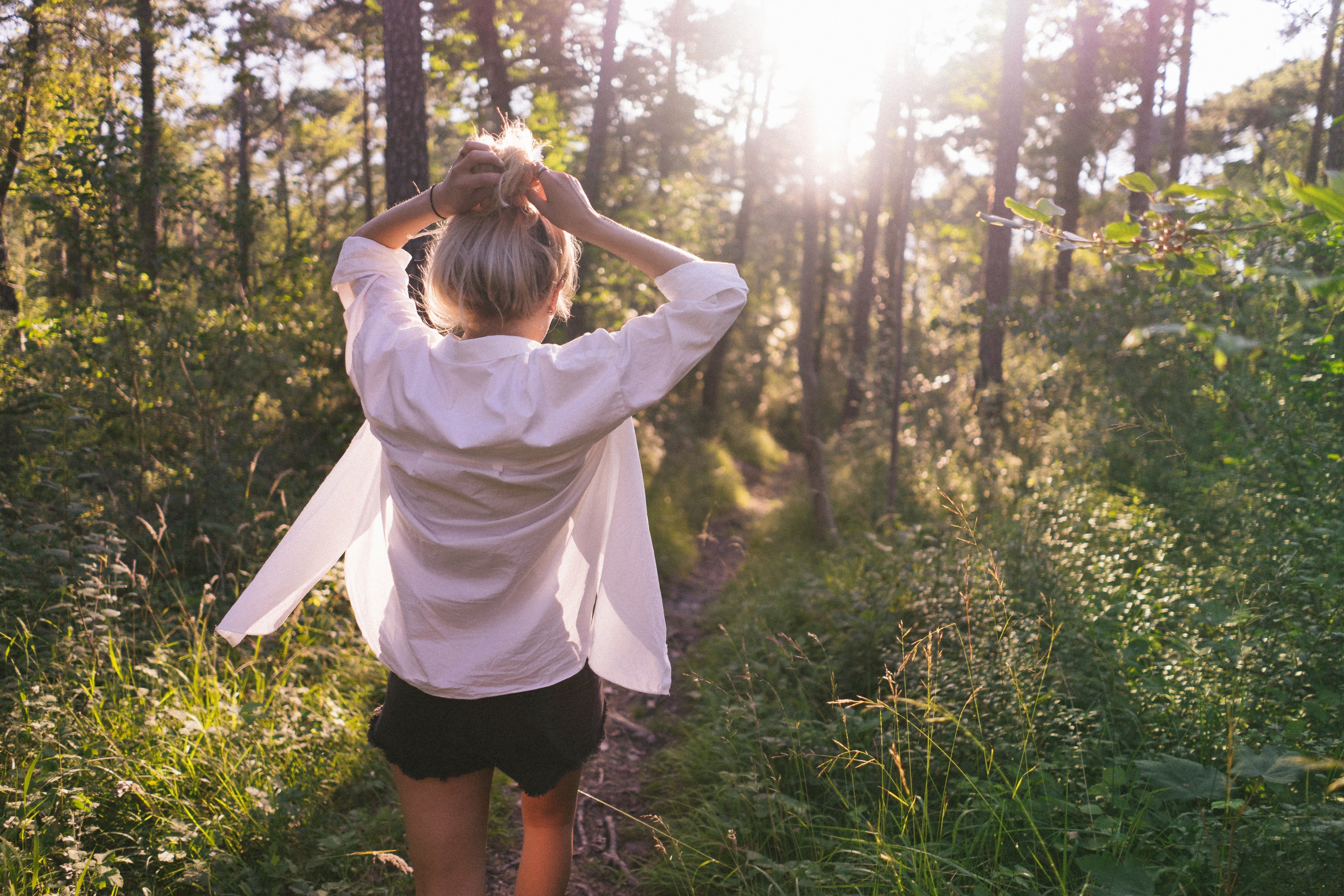 a woman in a white shirt and shorts on a narrow footpath in a forest in switzerland, lost in the forest 4k, HD Wallpaper