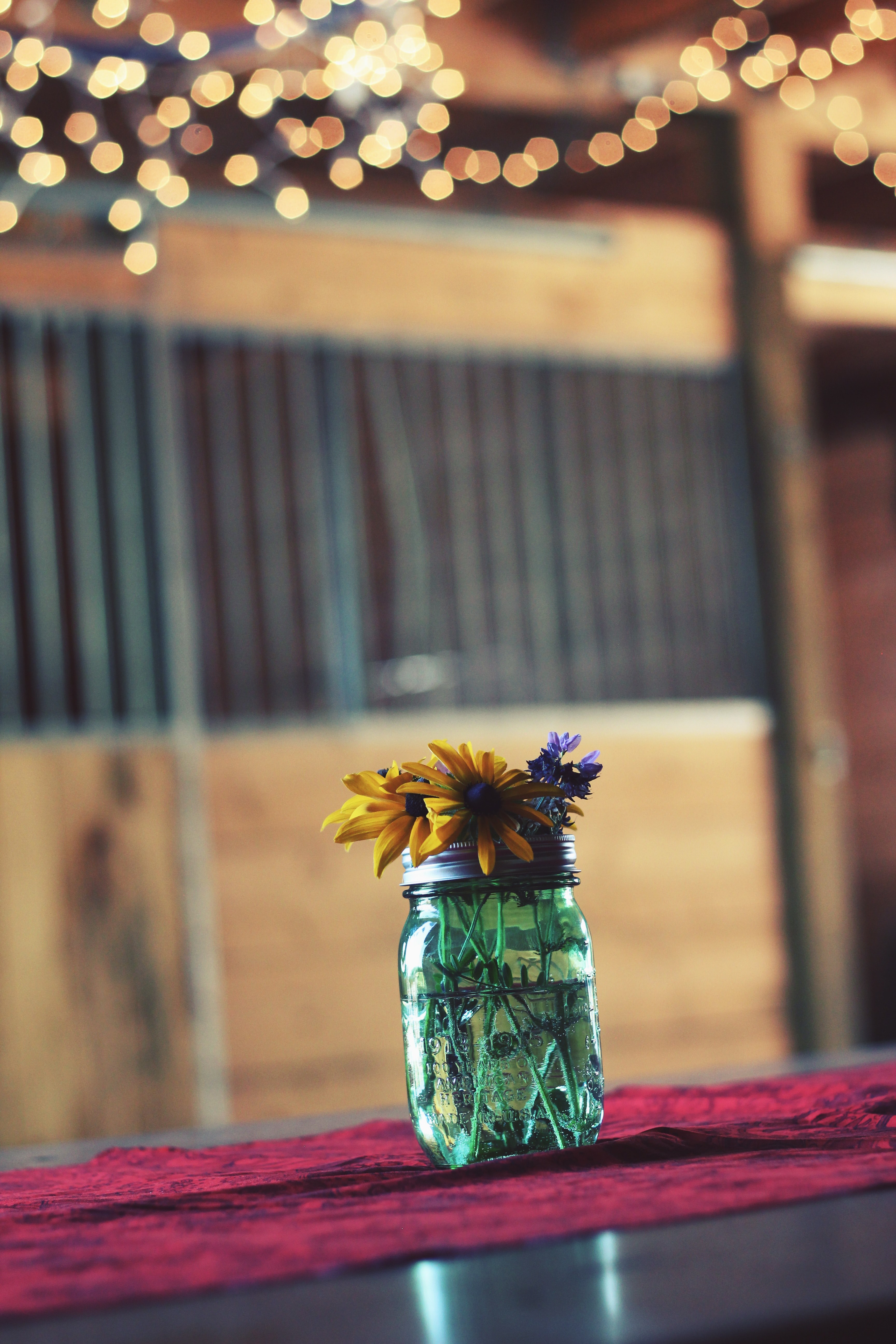 a glass jar with yellow and violet flowers on a wooden surface, modest flower jar 4k, Phone HD Wallpaper