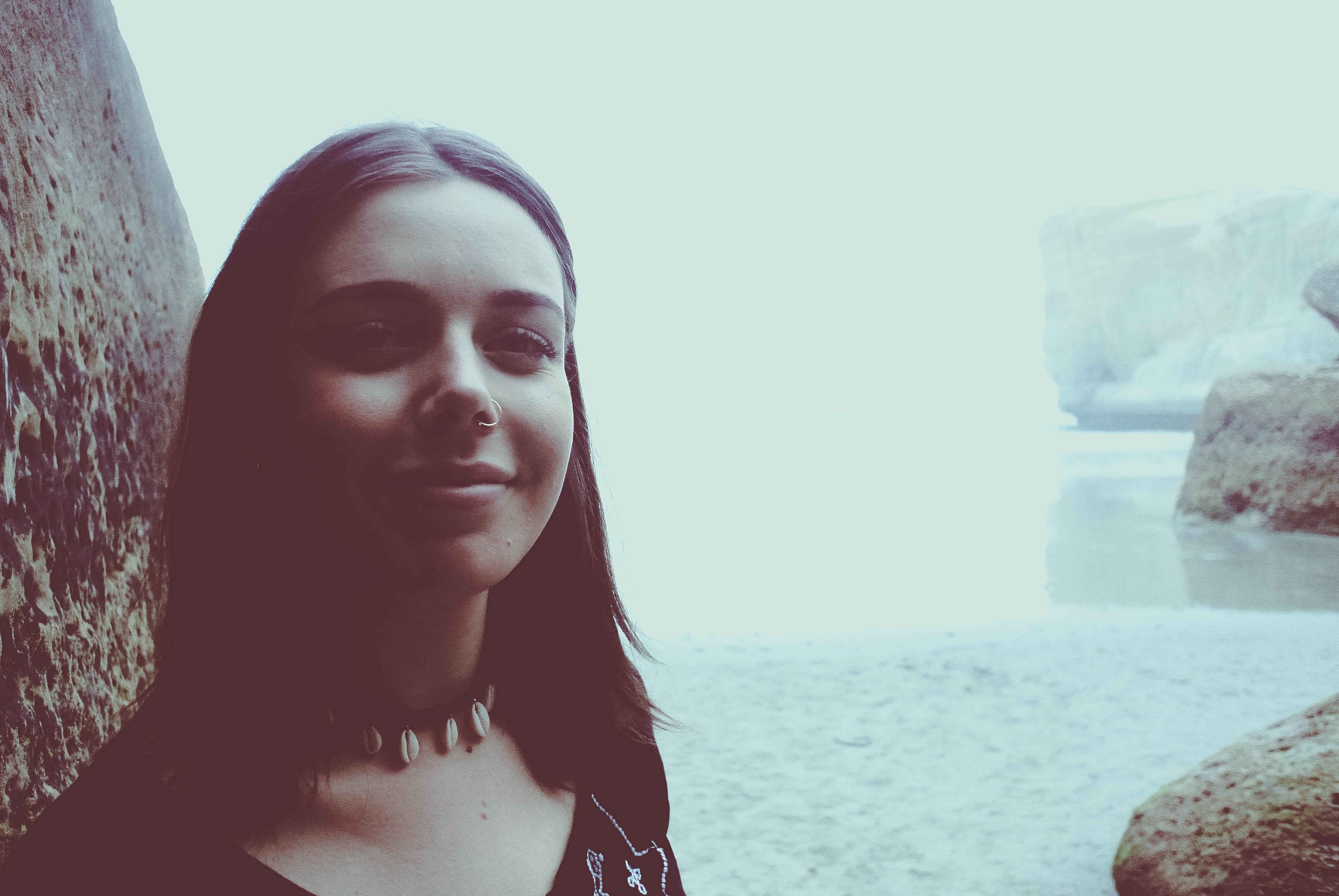 portrait of a woman with a nose ring smiling by the rocks at tunnel beach, the girl 4k, HD Wallpaper