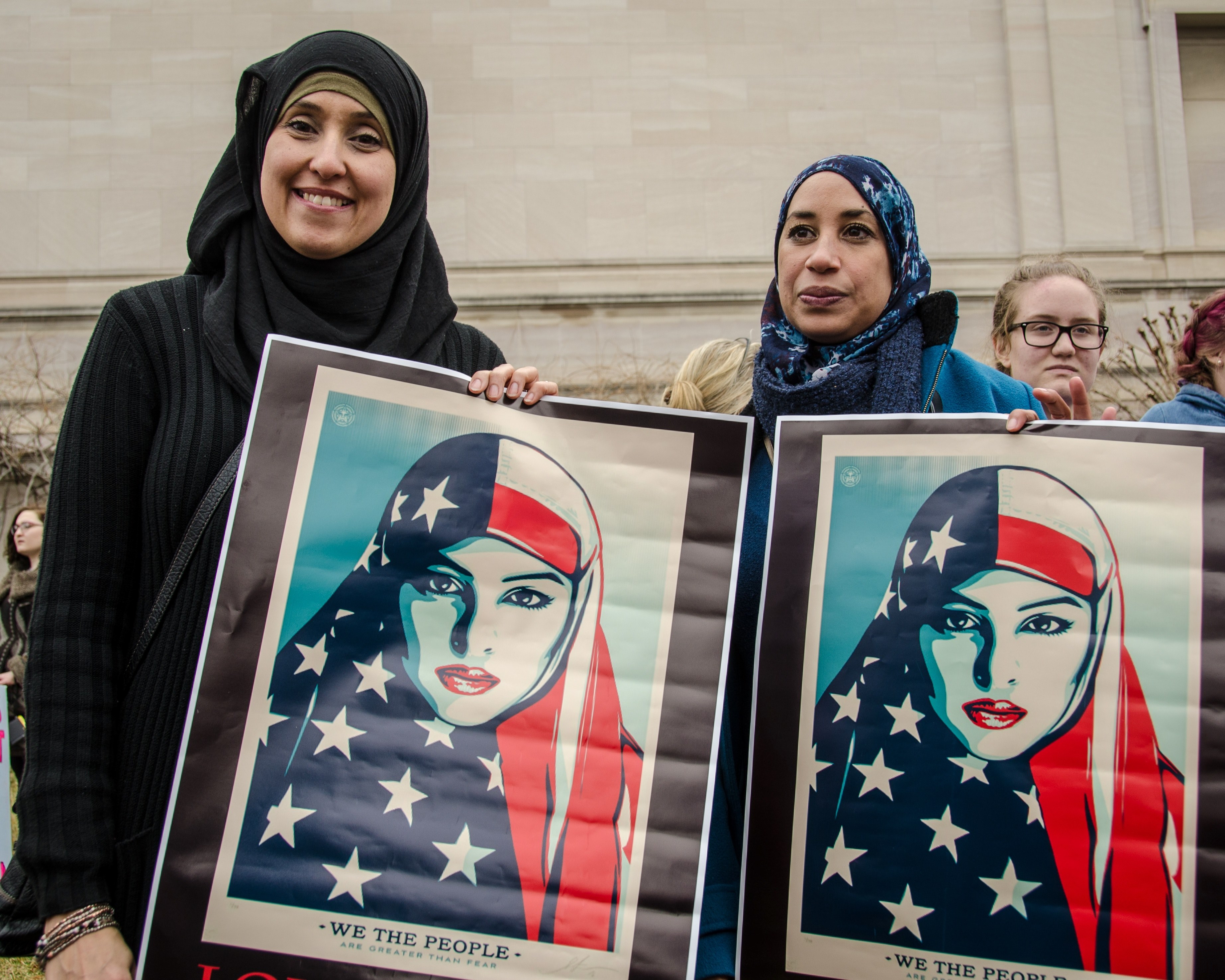 two women in hijabs hold posters of an american muslim woman at a march on washington, coming together in peaceful protest 4k, HD Wallpaper