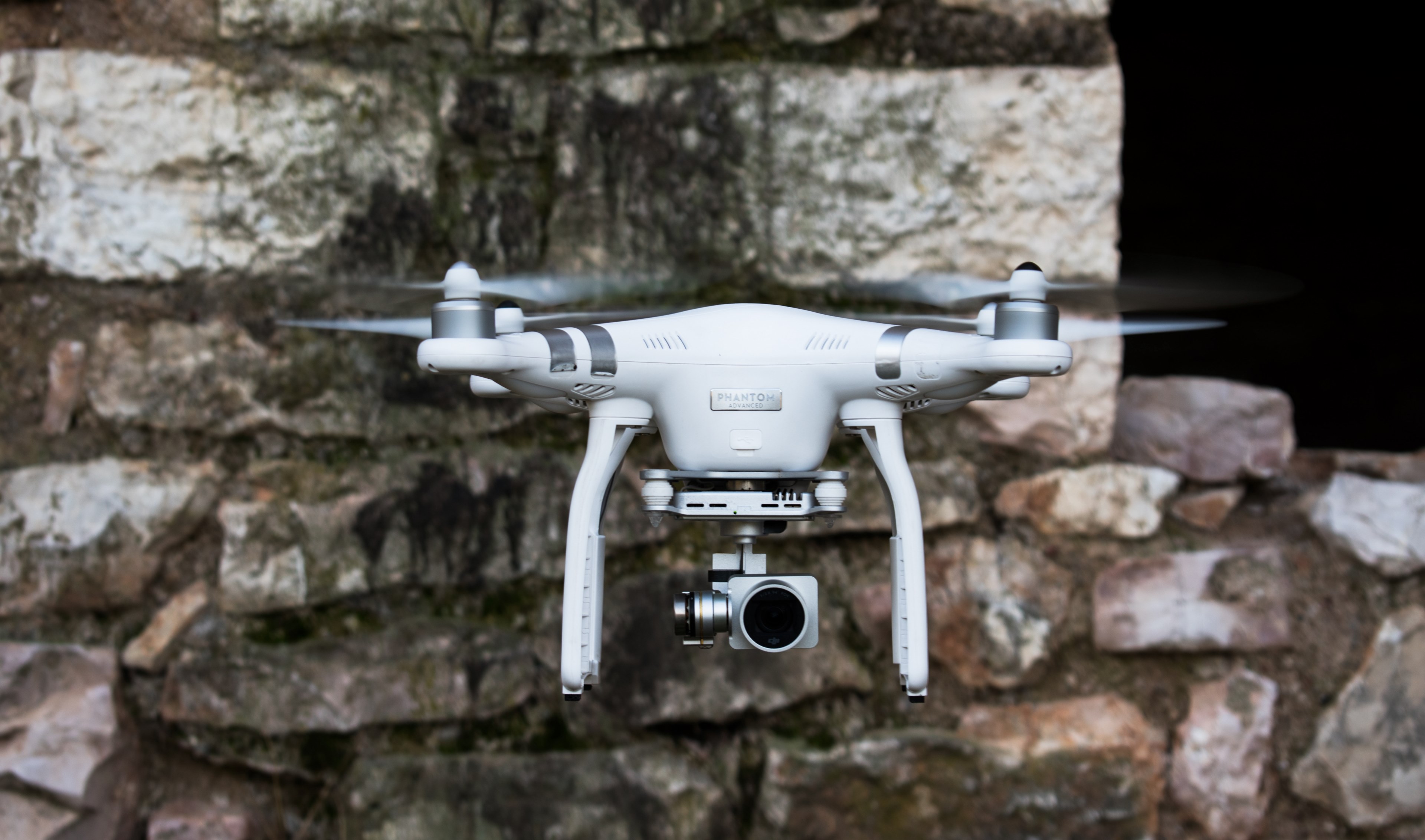 phantom dji drone hovering beside a stone wall, drone by stone wall 4k, HD Wallpaper