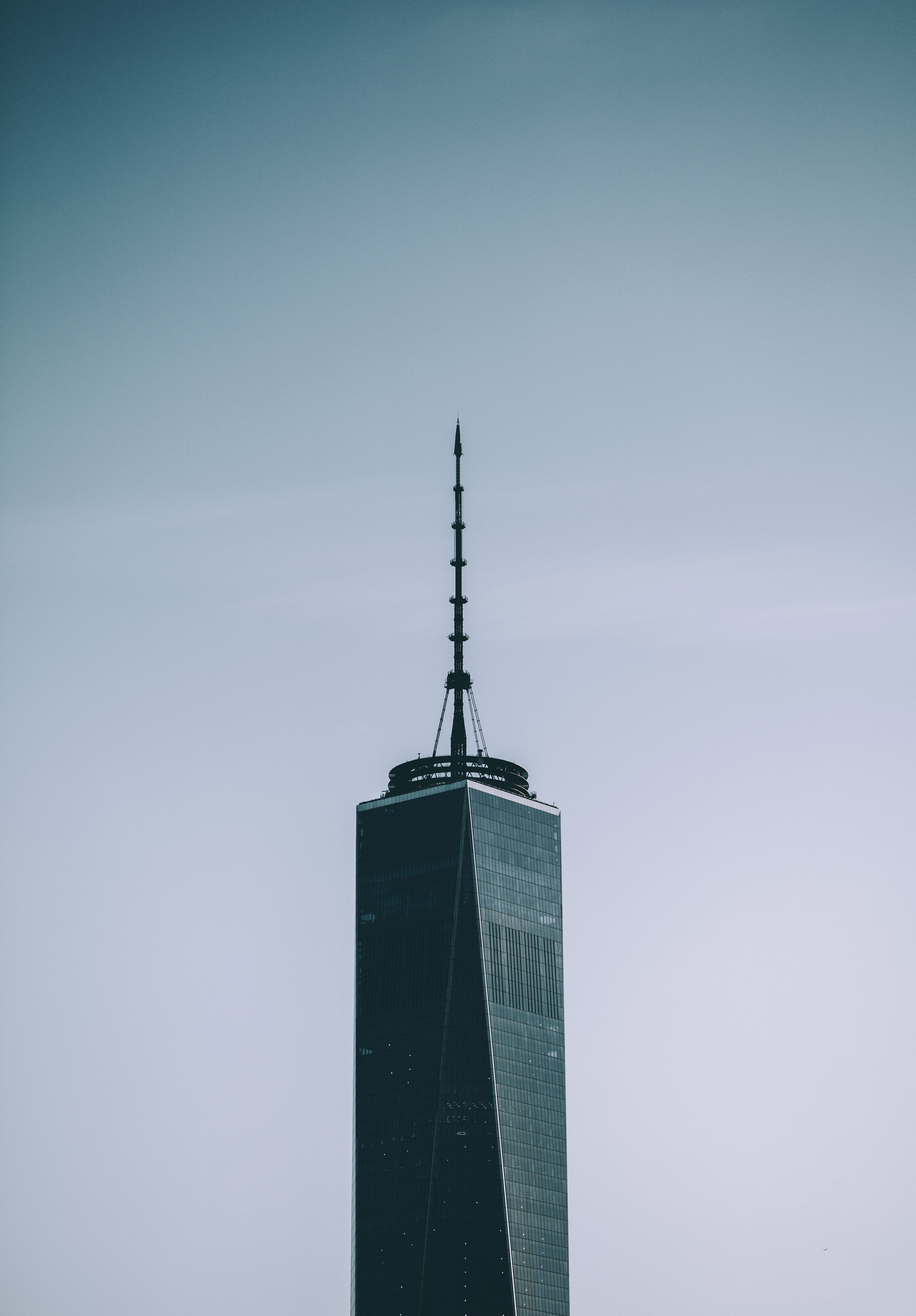 a skyscraper with a tall spire against a pale blue sky, skyscraper with a spire 4k, Phone HD Wallpaper