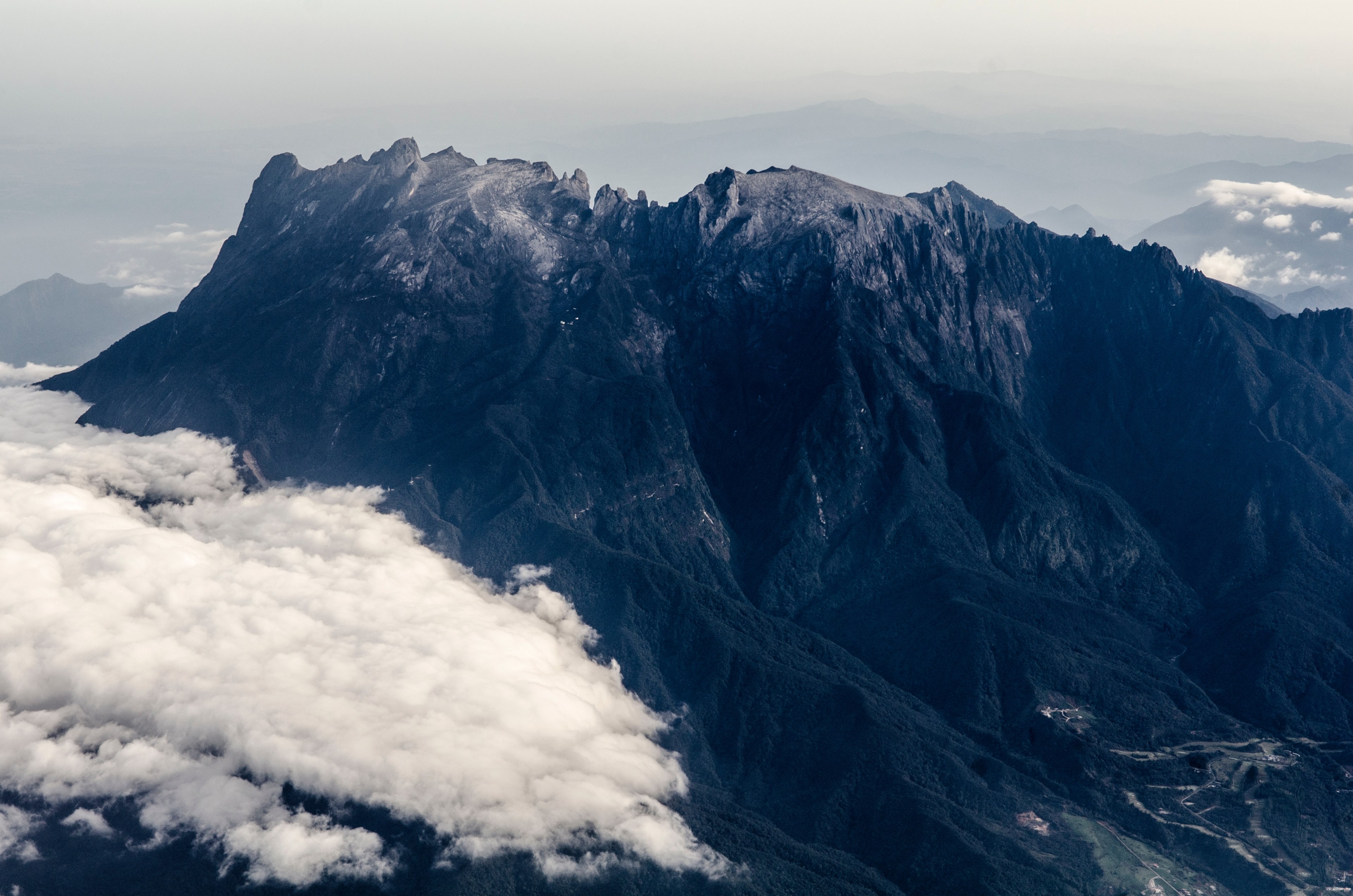 a dark granite mountain ridge towering over a white cloud, mountains crest above the clouds 4k, HD Wallpaper