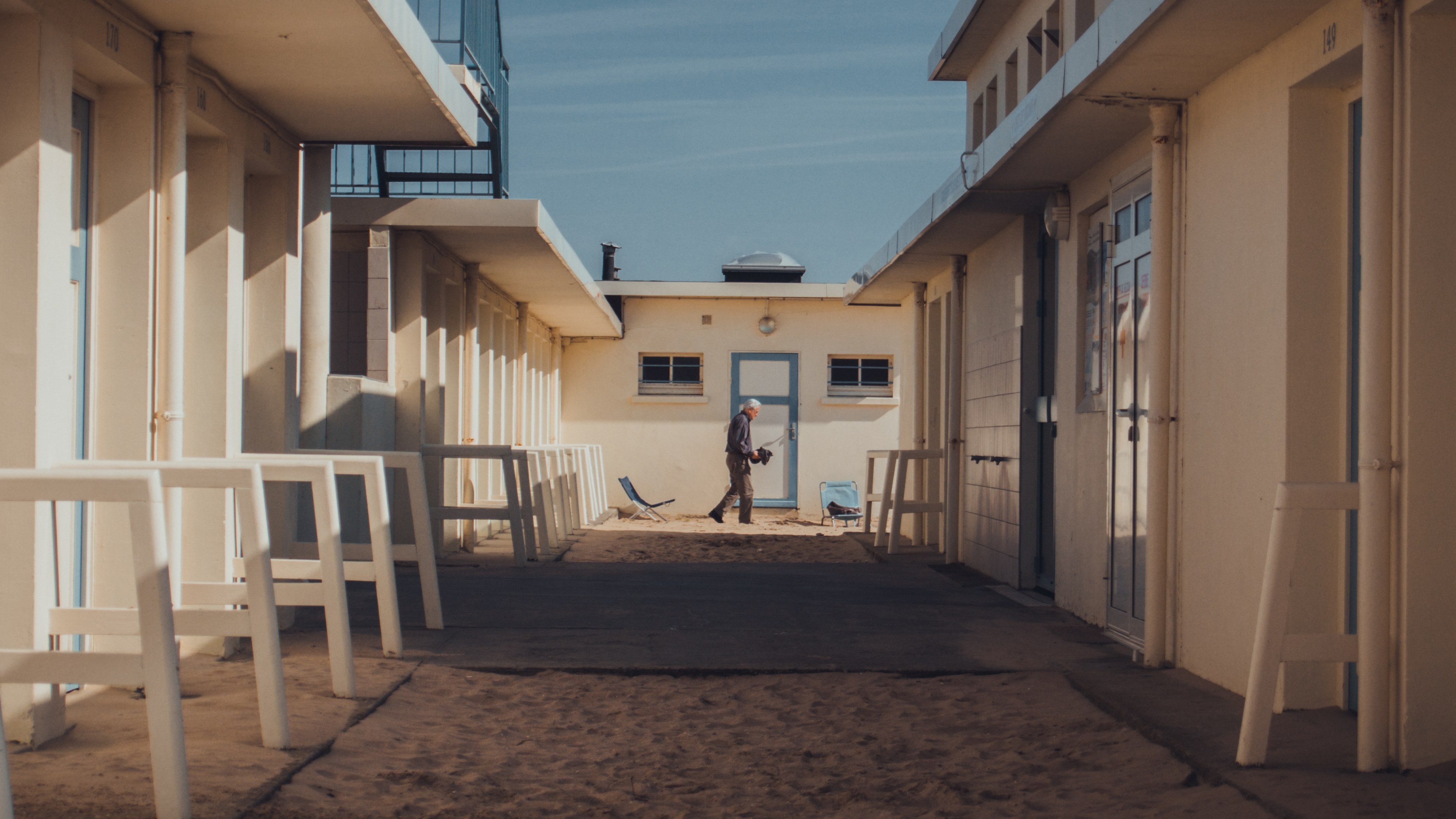 a man is seen walking past the holiday homes in trouville sur mer, _trouville beach 4k, HD Wallpaper
