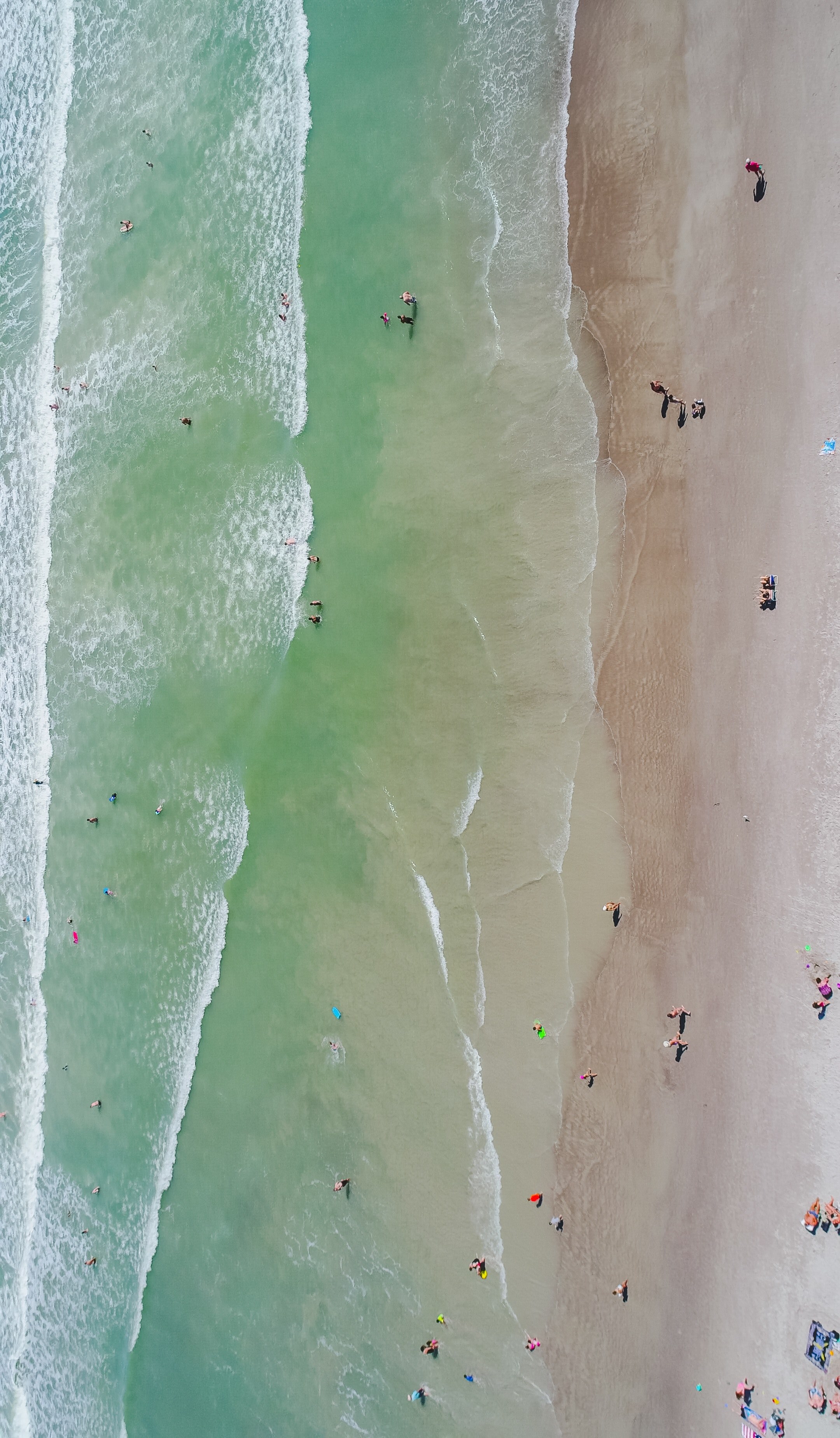 a drone shot of tourists sunbathing on a golden beach and swimming in warm sea water, top view of a sunlit orlando beach 4k, Phone HD Wallpaper