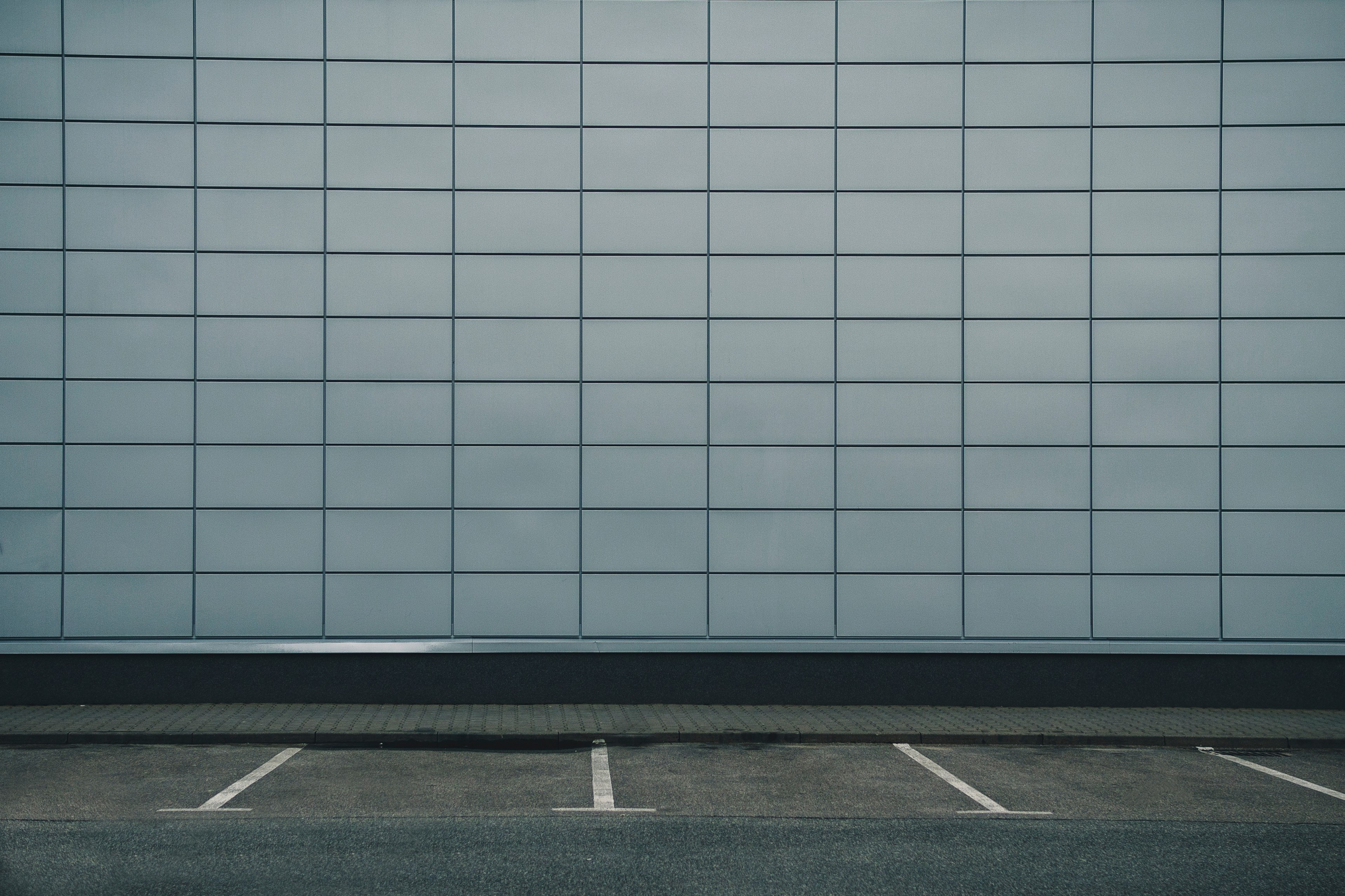 an empty parking lot against a grey tiled wall of a building, _greys 4k, HD Wallpaper