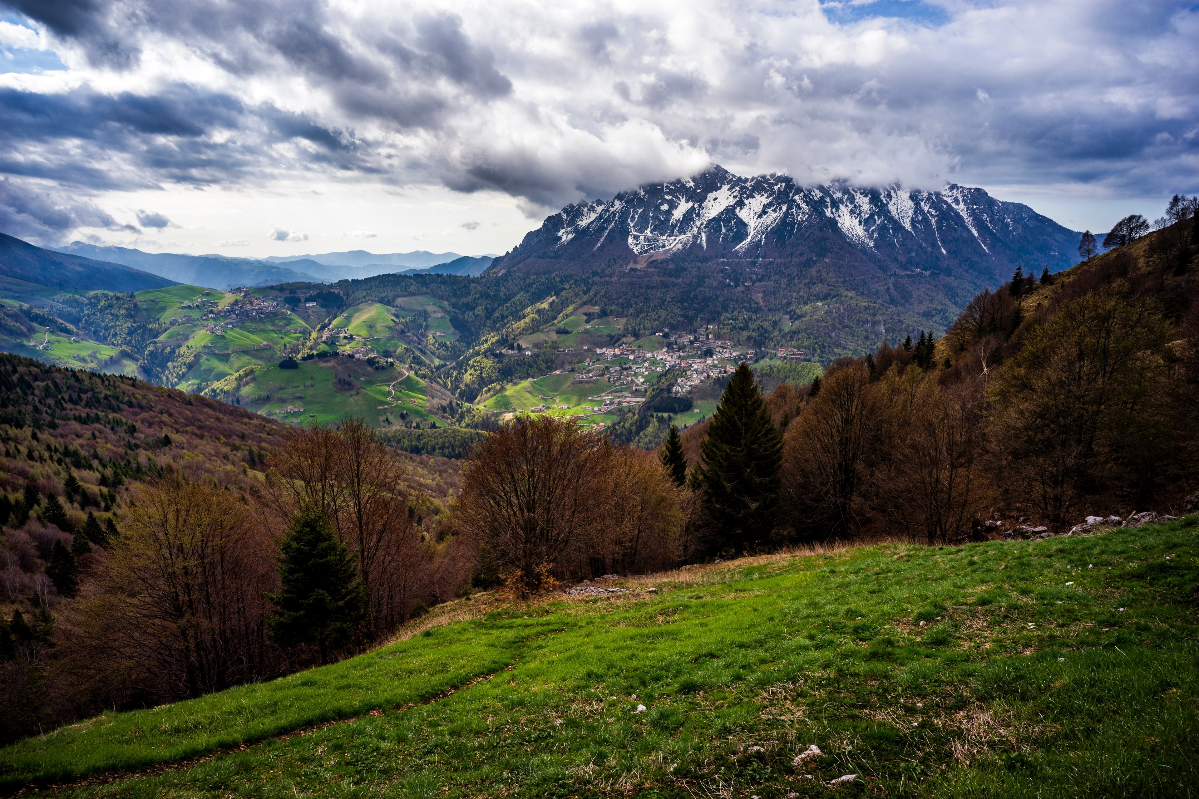 a picturesque landscape with snowy mountains towering over a village on hills, village near snowy mountains 4k, HD Wallpaper