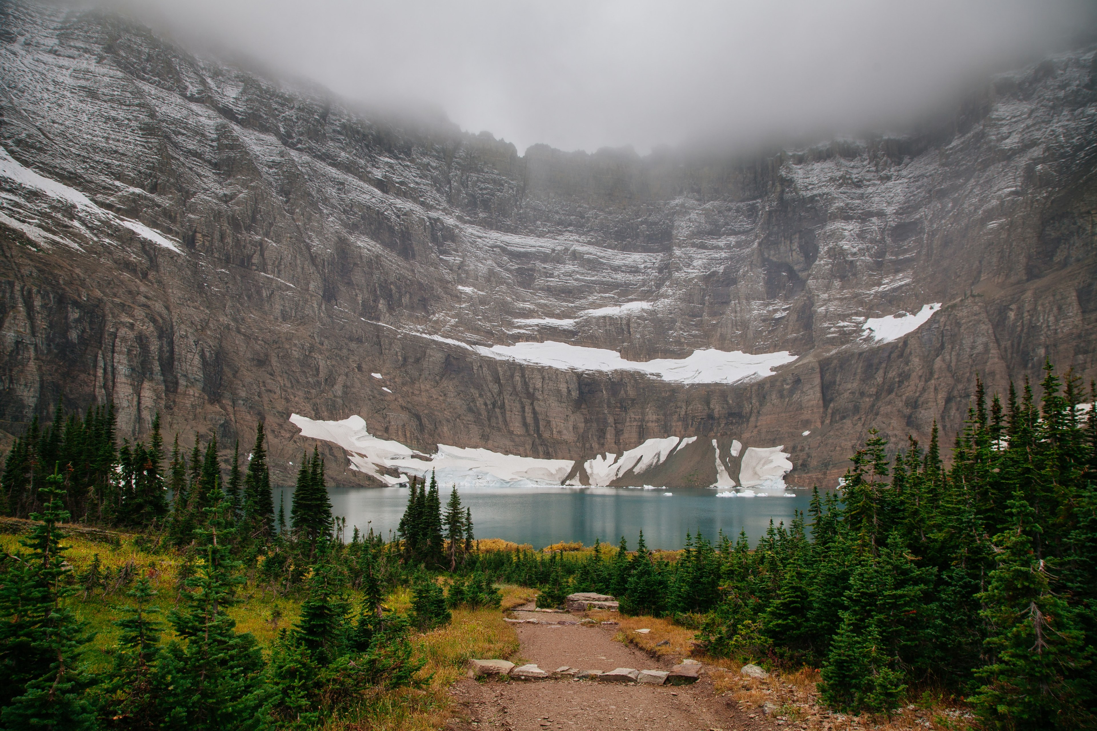 fog circling above snowy mountains leading down to iceberg lake surrounded by trees, small icy lake 4k, HD Wallpaper