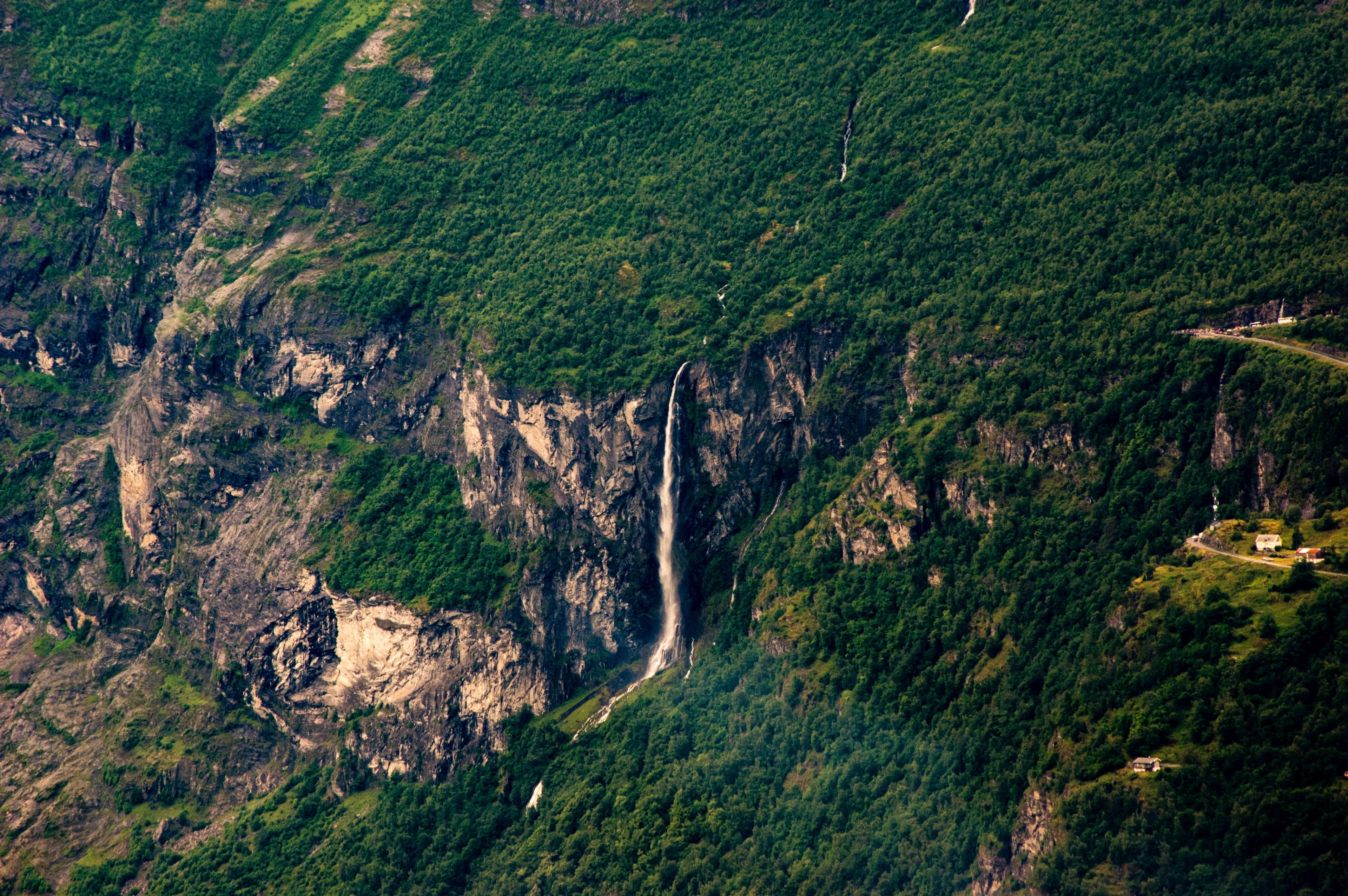 a drone shot of a waterfall tumbling from a rocky face into a green forest, remote waterfall from above 4k, HD Wallpaper