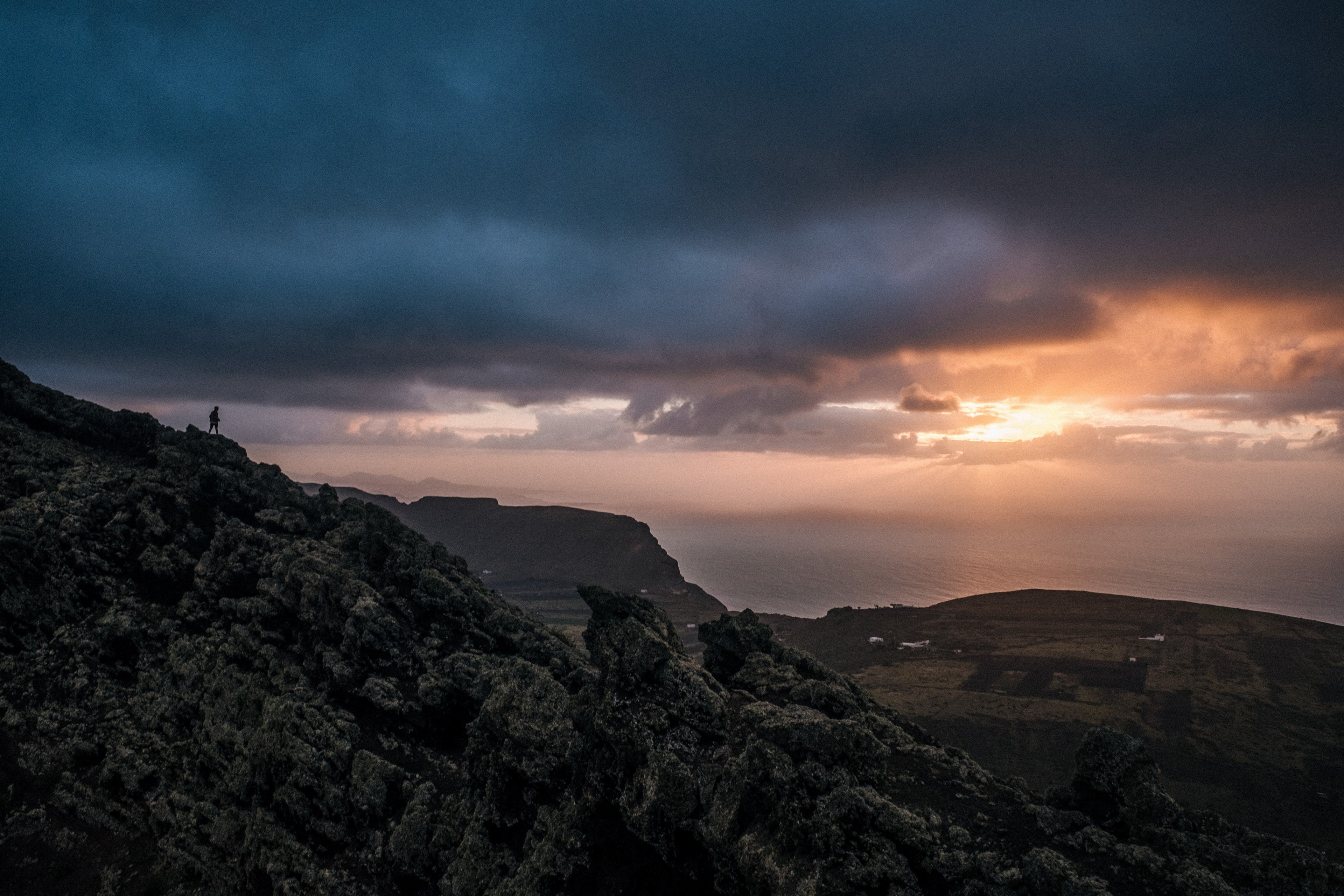 silhouette of a lone hiker on a craggy ridge overlooking the sea at dusk, on a tall ridge at dusk 4k, HD Wallpaper