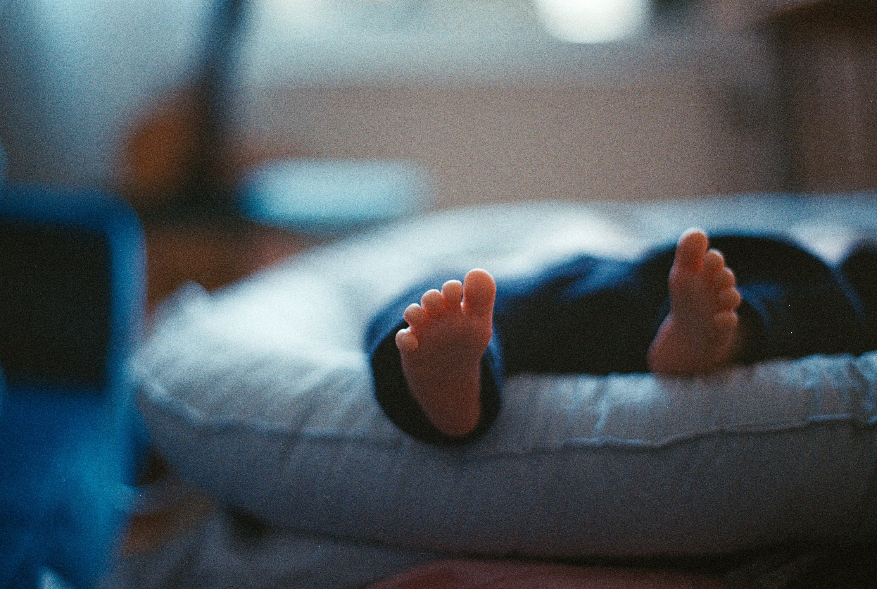 an up close view of an infants feet against a blurred view of the baby lying on a blue mat, _an infants feet 4k, HD Wallpaper