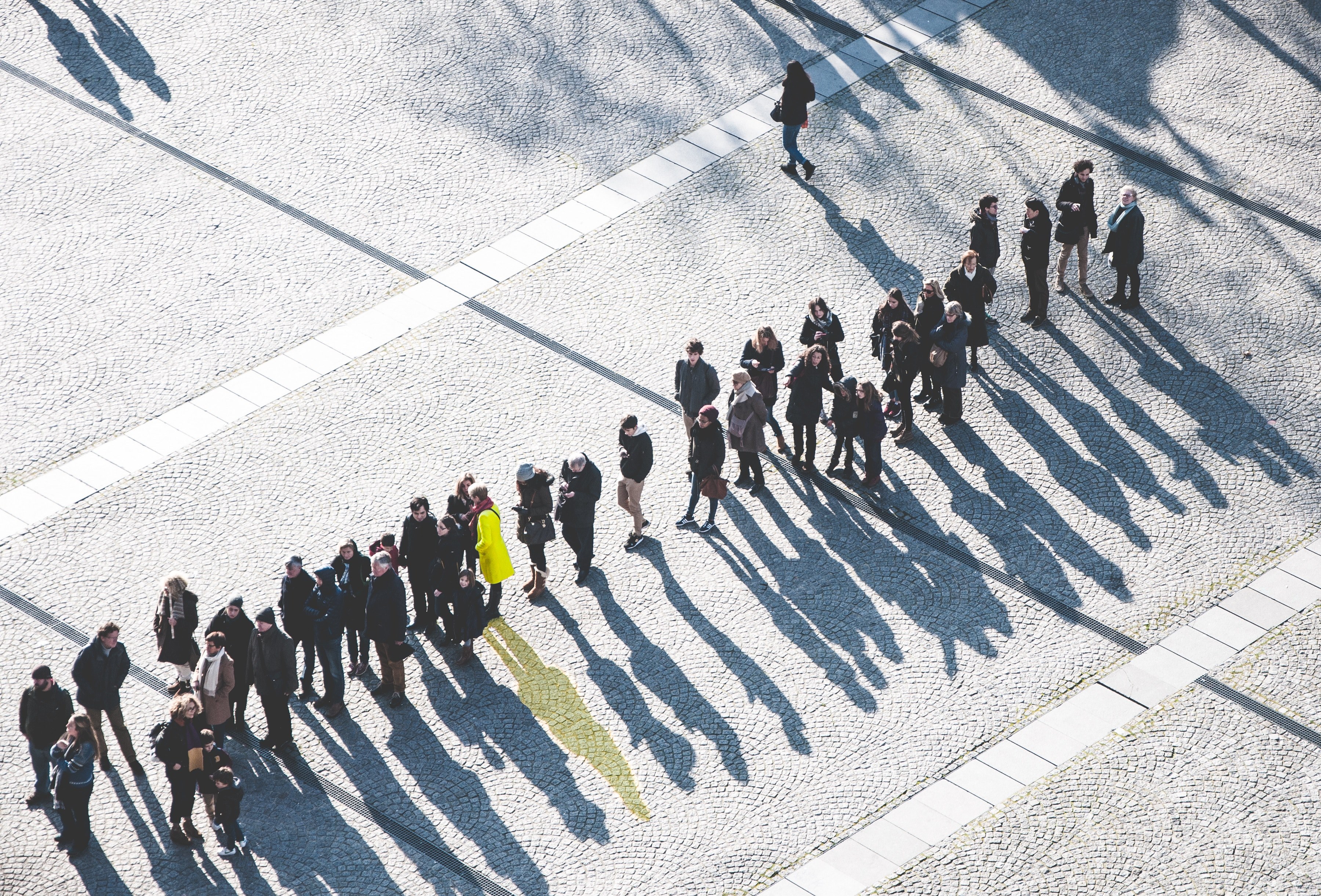 a woman in a yellow jacket standing amongst a group of people in black jacket, lineup with one yellow shadow 4k, HD Wallpaper