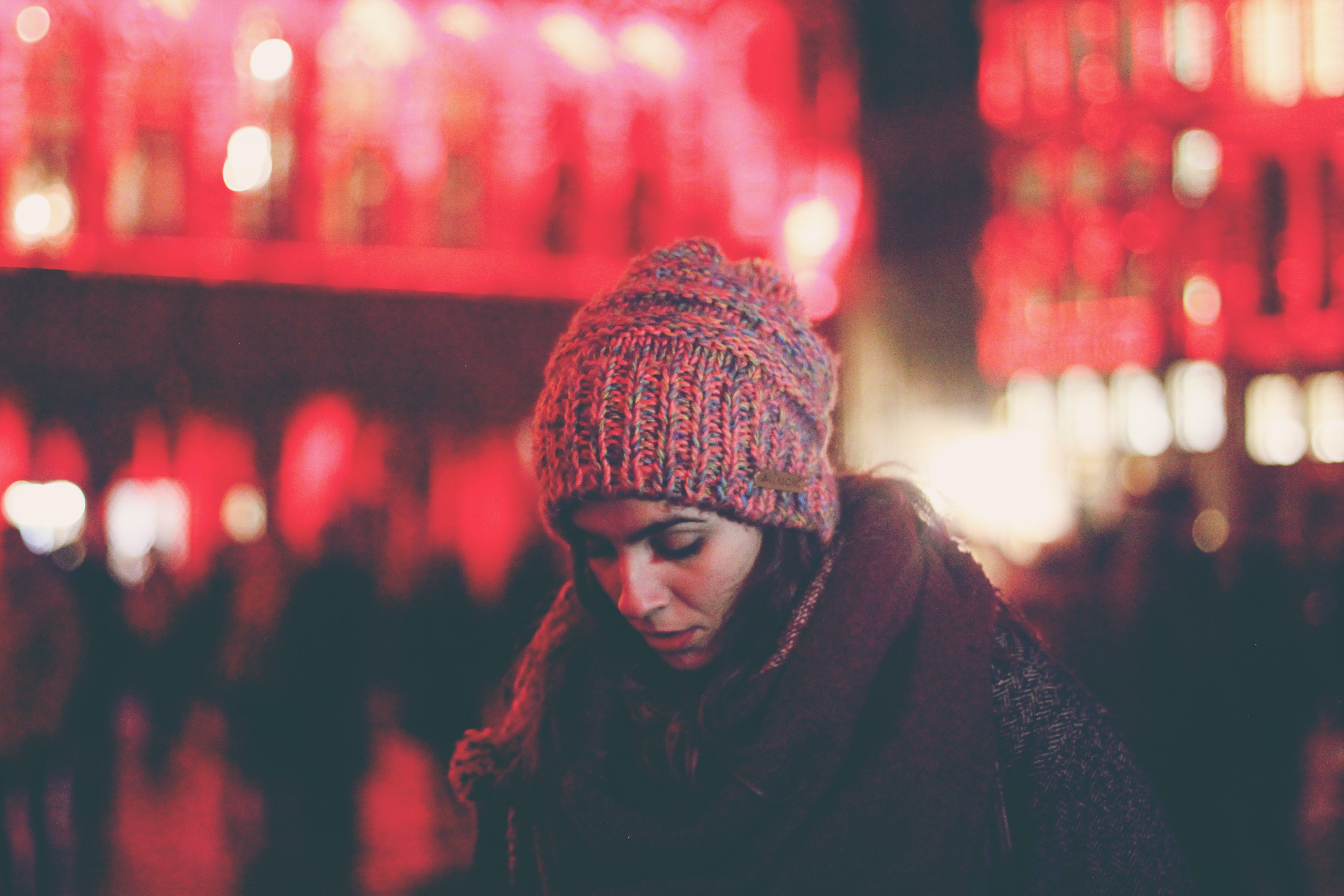 a woman in a knit cap looks down against red lights at the grand palace, brussels lights 4k, HD Wallpaper