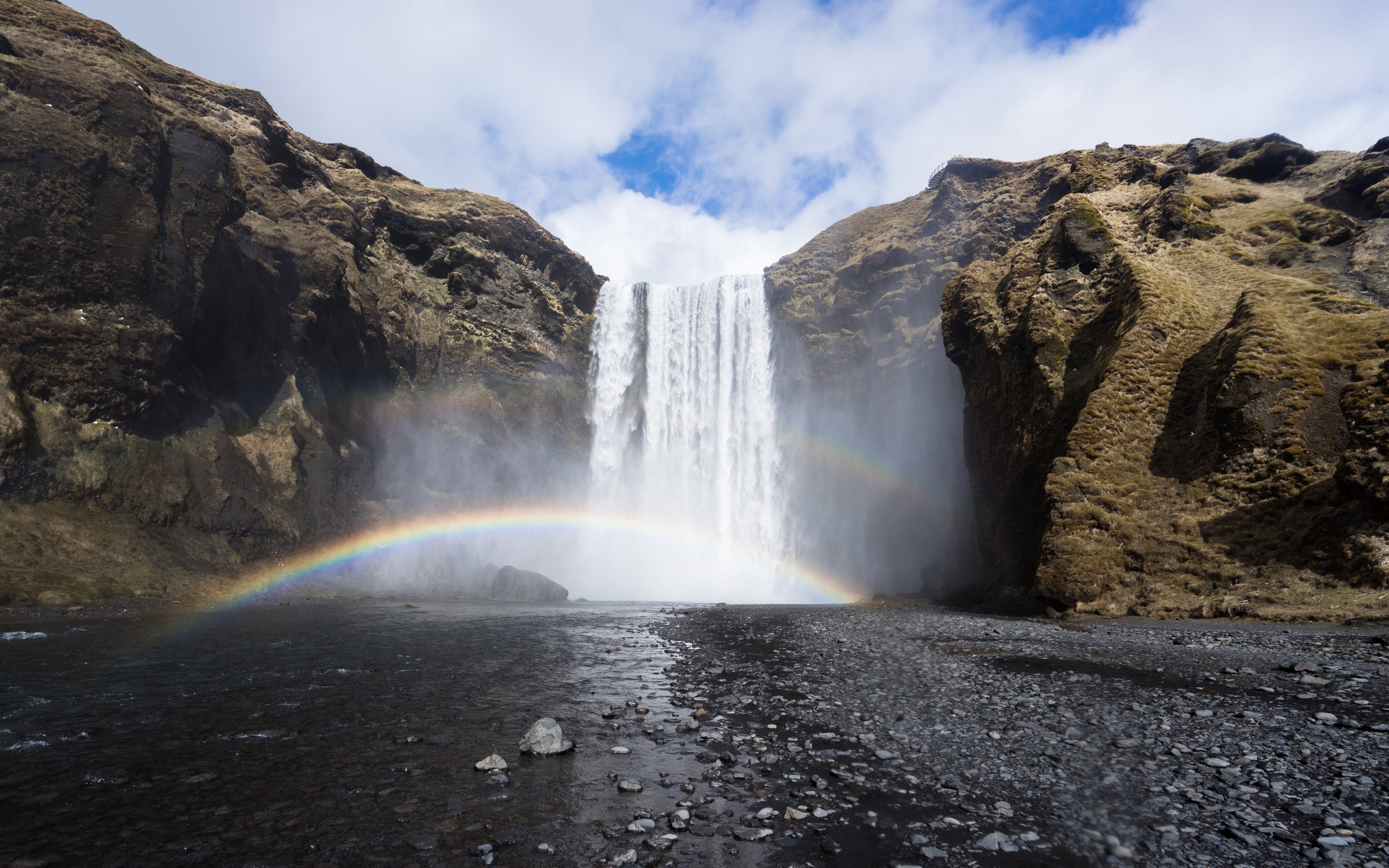 a magnificent shot of a waterfall tumbling down from a rock with a small rainbow in the spraying water, rainbow under skgafoss waterfall 4k, HD Wallpaper