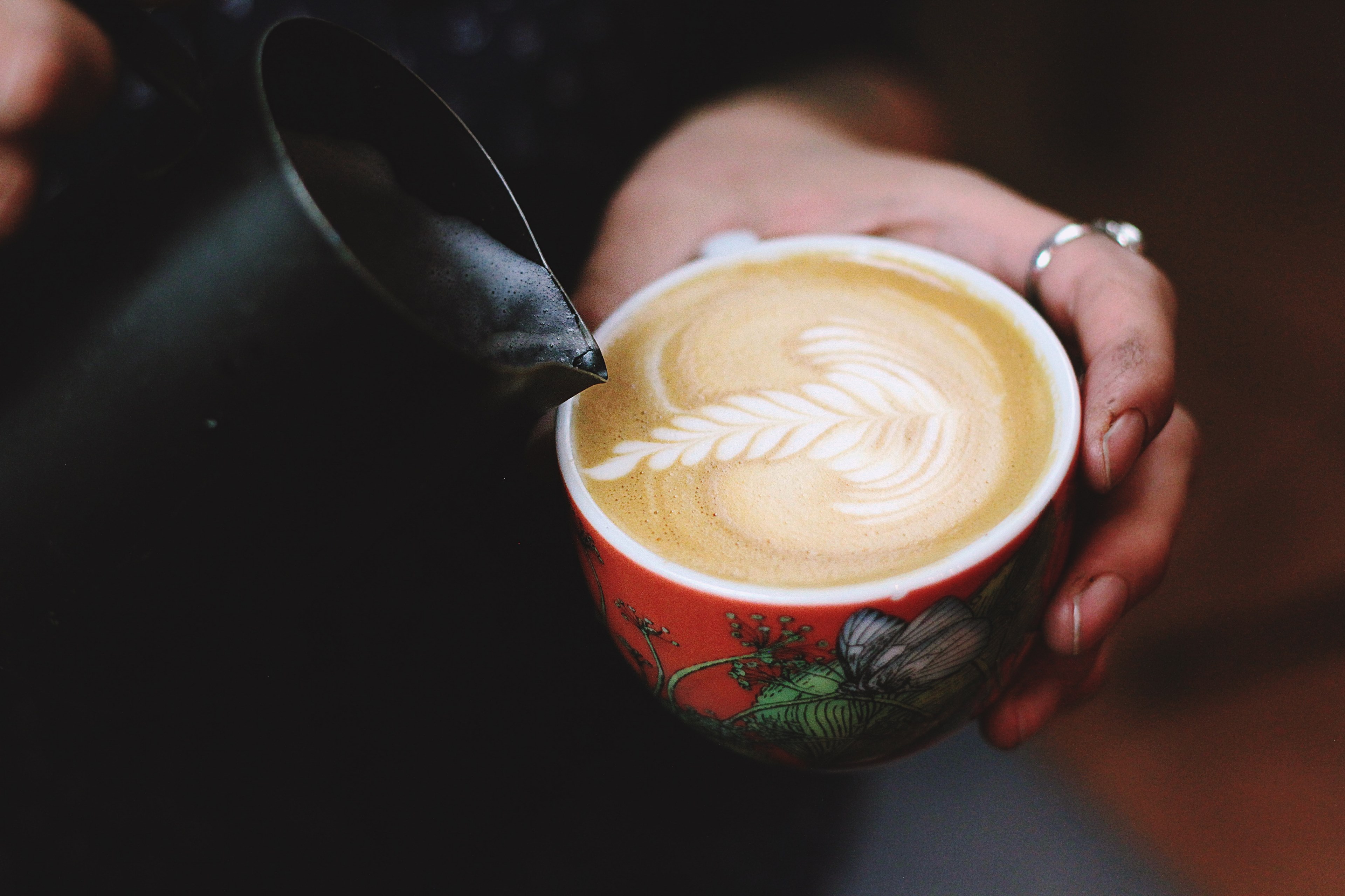 cappuccino being poured into a decorative red mug with leaf like foam art, latte art 4k, HD Wallpaper