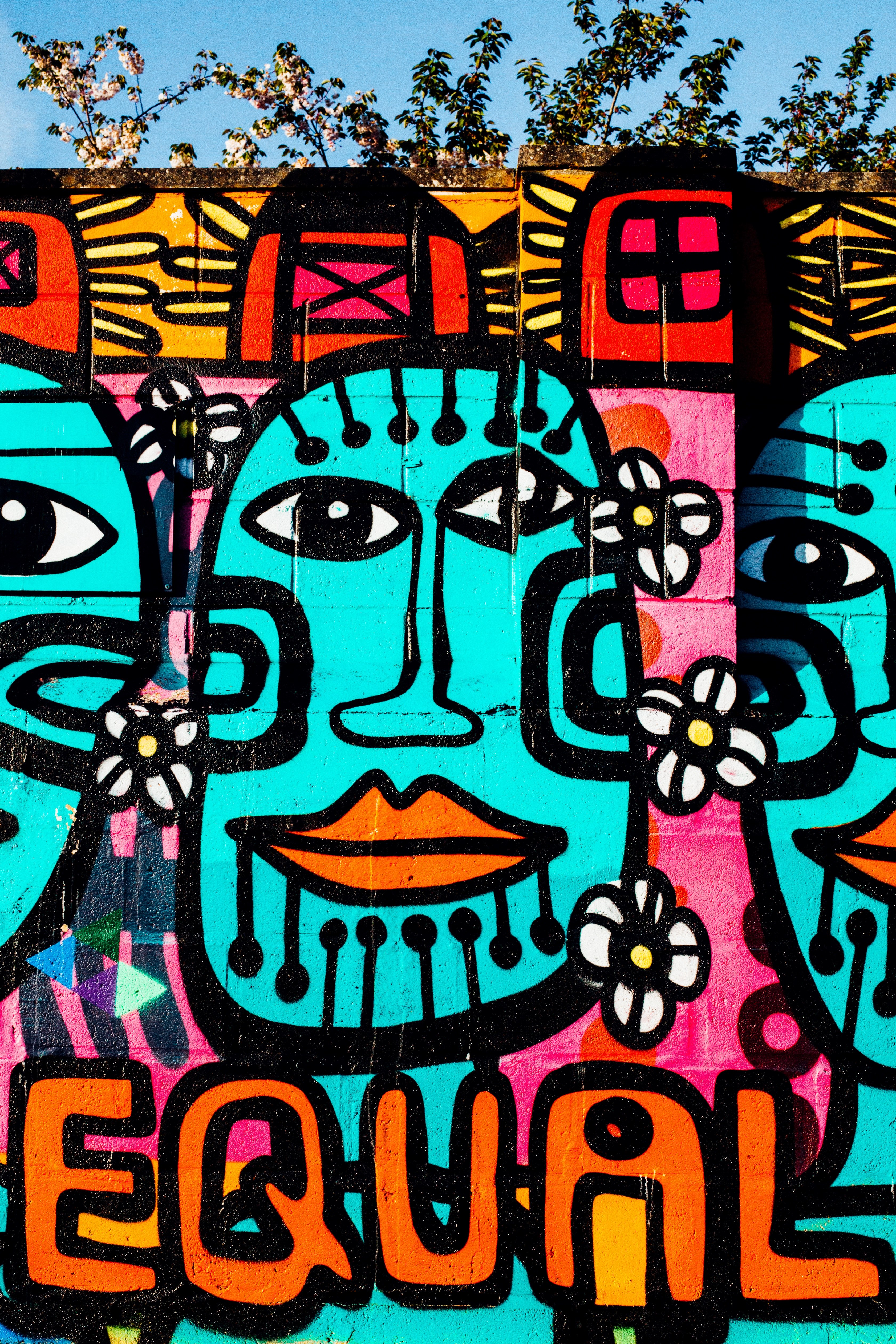 brightly colored urban graffiti mural artwork on wall with equal text and tribal faces, brick wall painting of faces 4k, Phone HD Wallpaper
