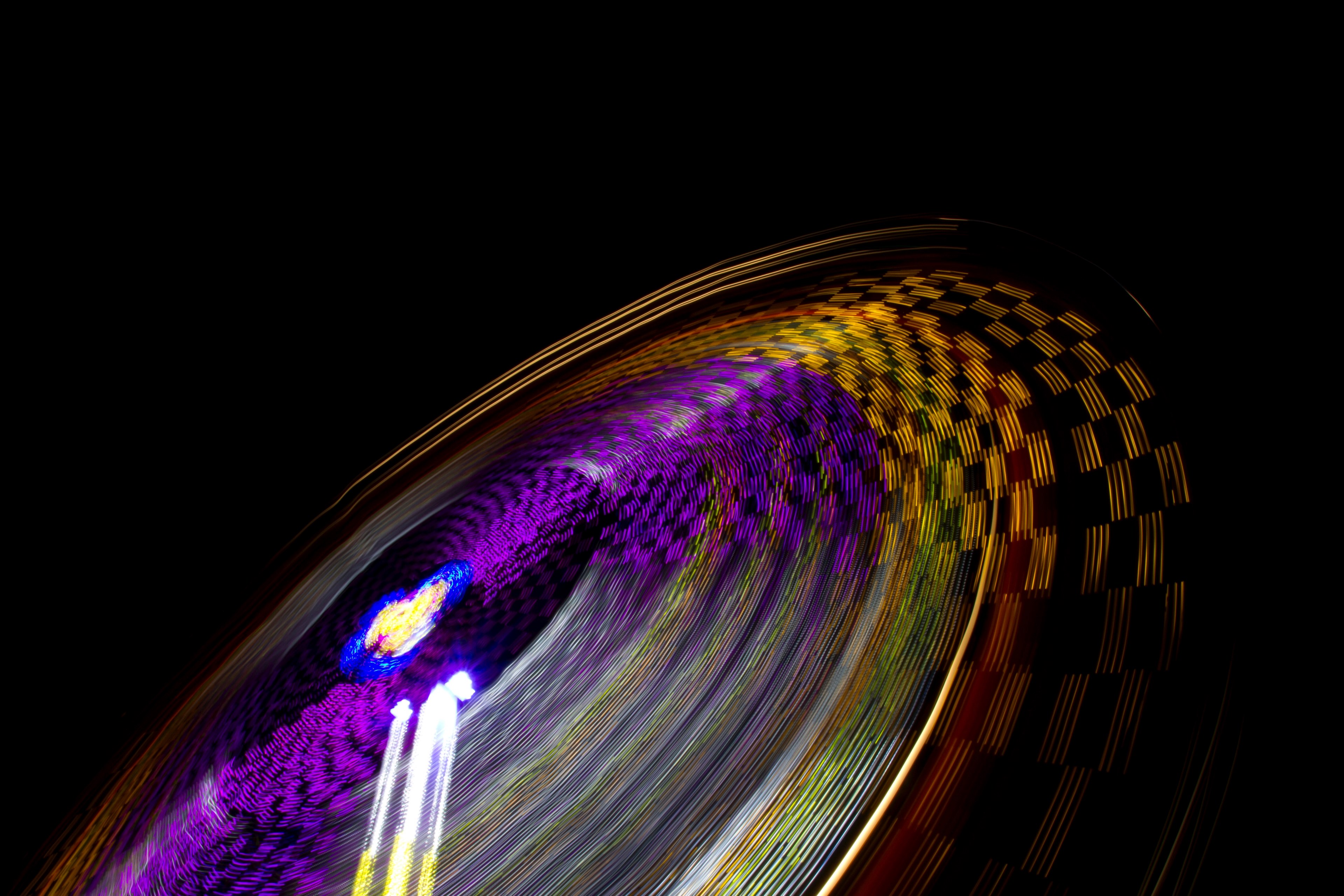 a blurred shot showcasing colorful light trails from a spinning amusement park ride, fairground ride in motion 4k, HD Wallpaper