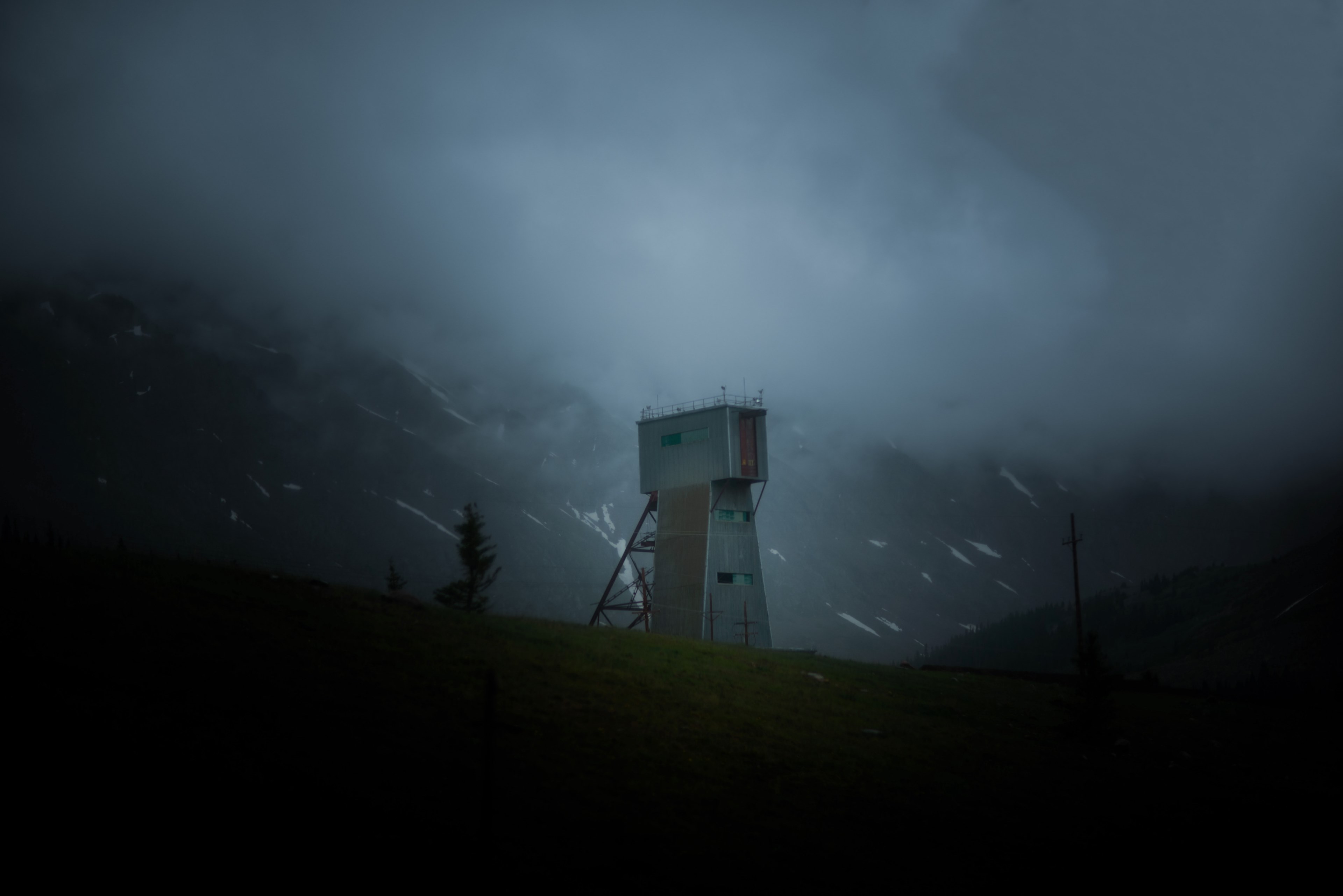 desolate lookout tower in rocky mountainside on a stormy night, spooky ranger station 4k, HD Wallpaper