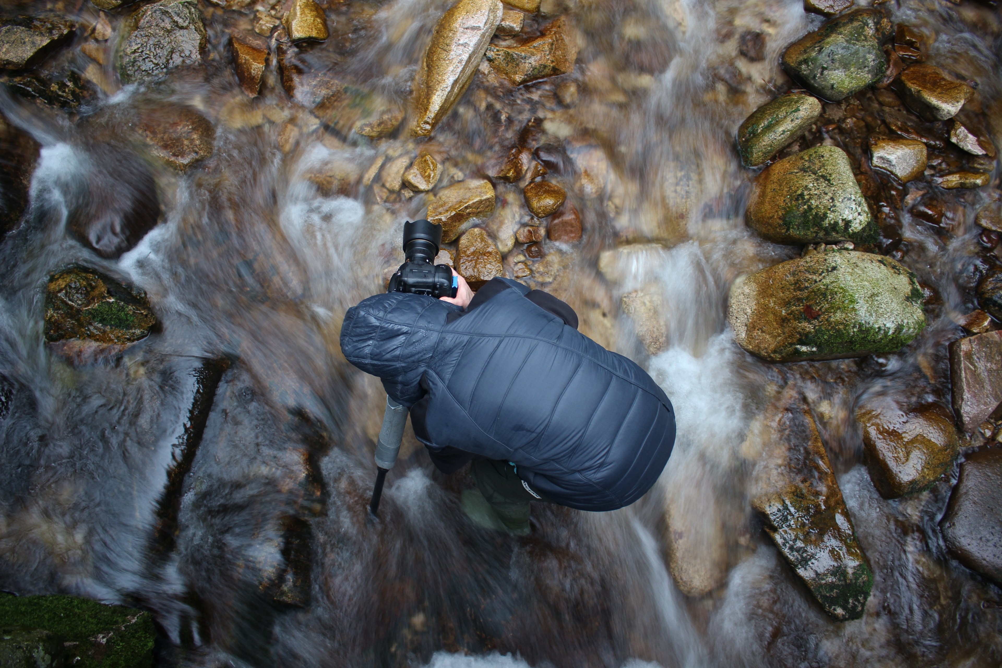a photographer planting a tripod on a rocky bed of a creek, photographer in a creek 4k, HD Wallpaper