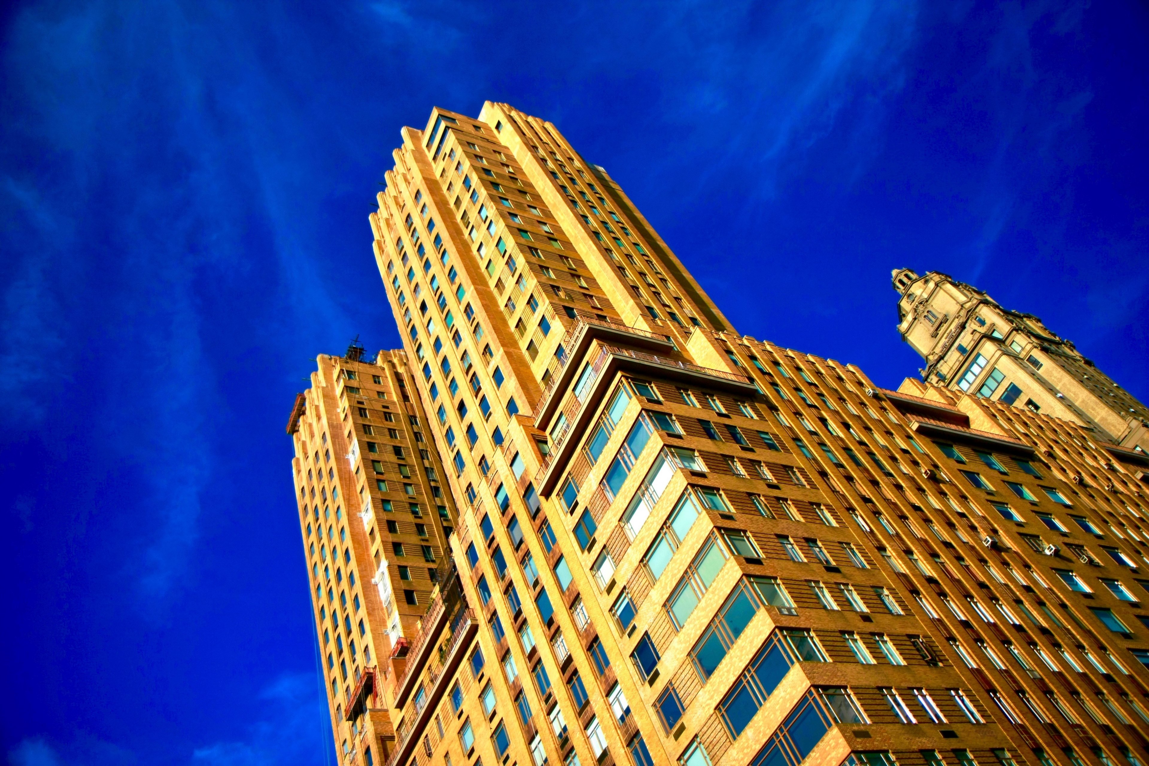 ground view of a brown brick building against a bright blue sky, the skies such a sweet blue 4k, HD Wallpaper