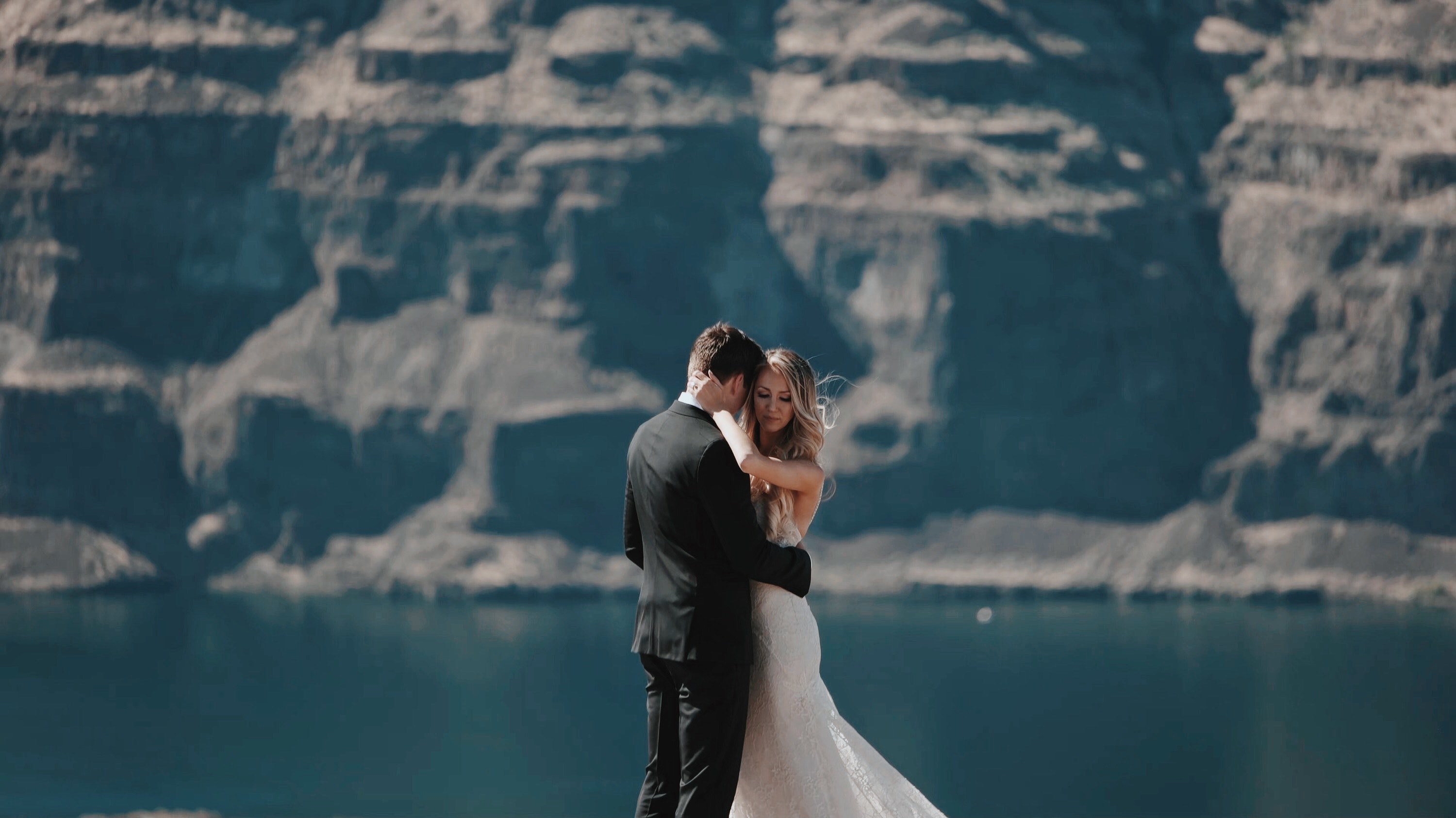 a bride and groom embrace on a vista overlooking a body of water and cliff, wedding couple hug on cliff 4k, HD Wallpaper