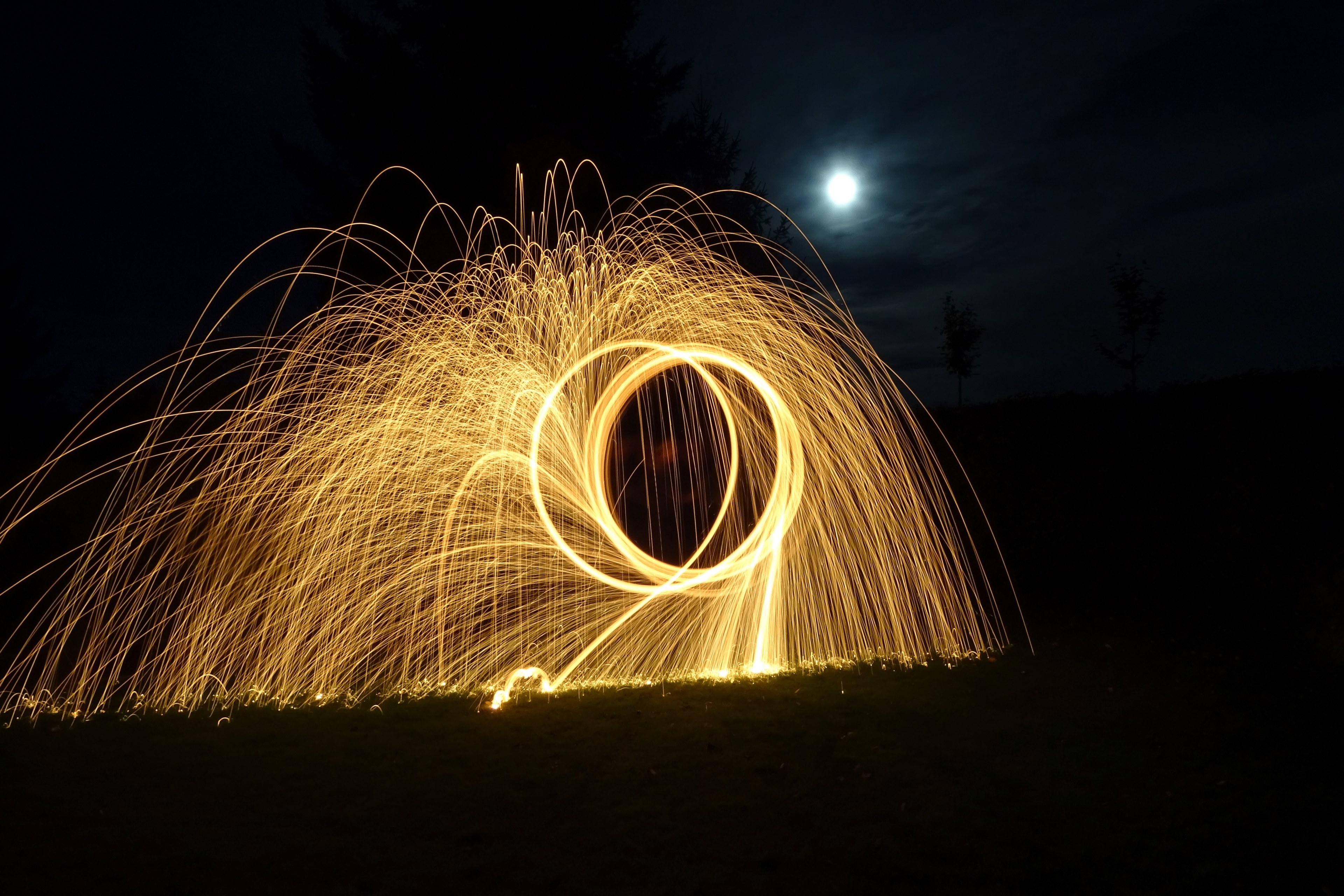light trails caused from long exposure simulating a hoop shape and fireworks in a dark moonlit night, iron wool 4k, HD Wallpaper