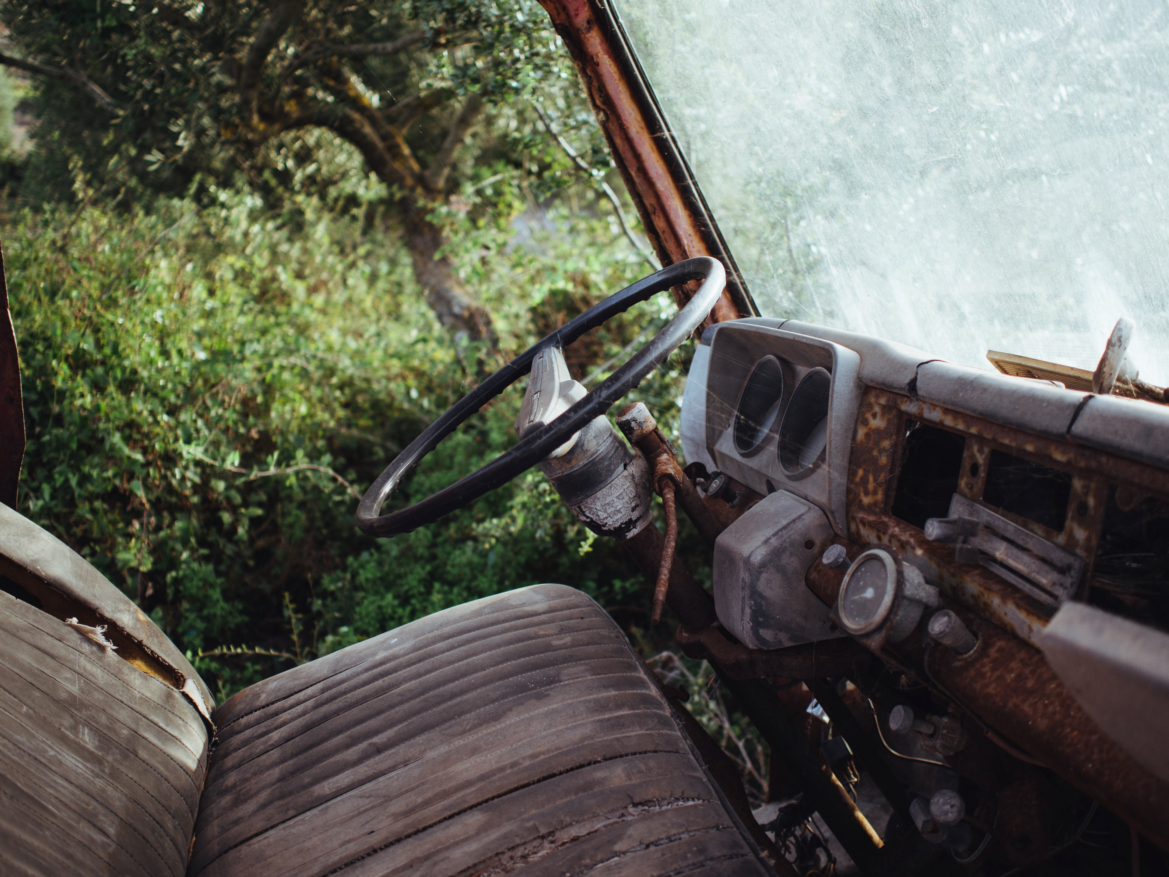 interior shot of rusty old vehicle with worn seats parked near trees, rusty old vehicle with worn seats 4k, HD Wallpaper