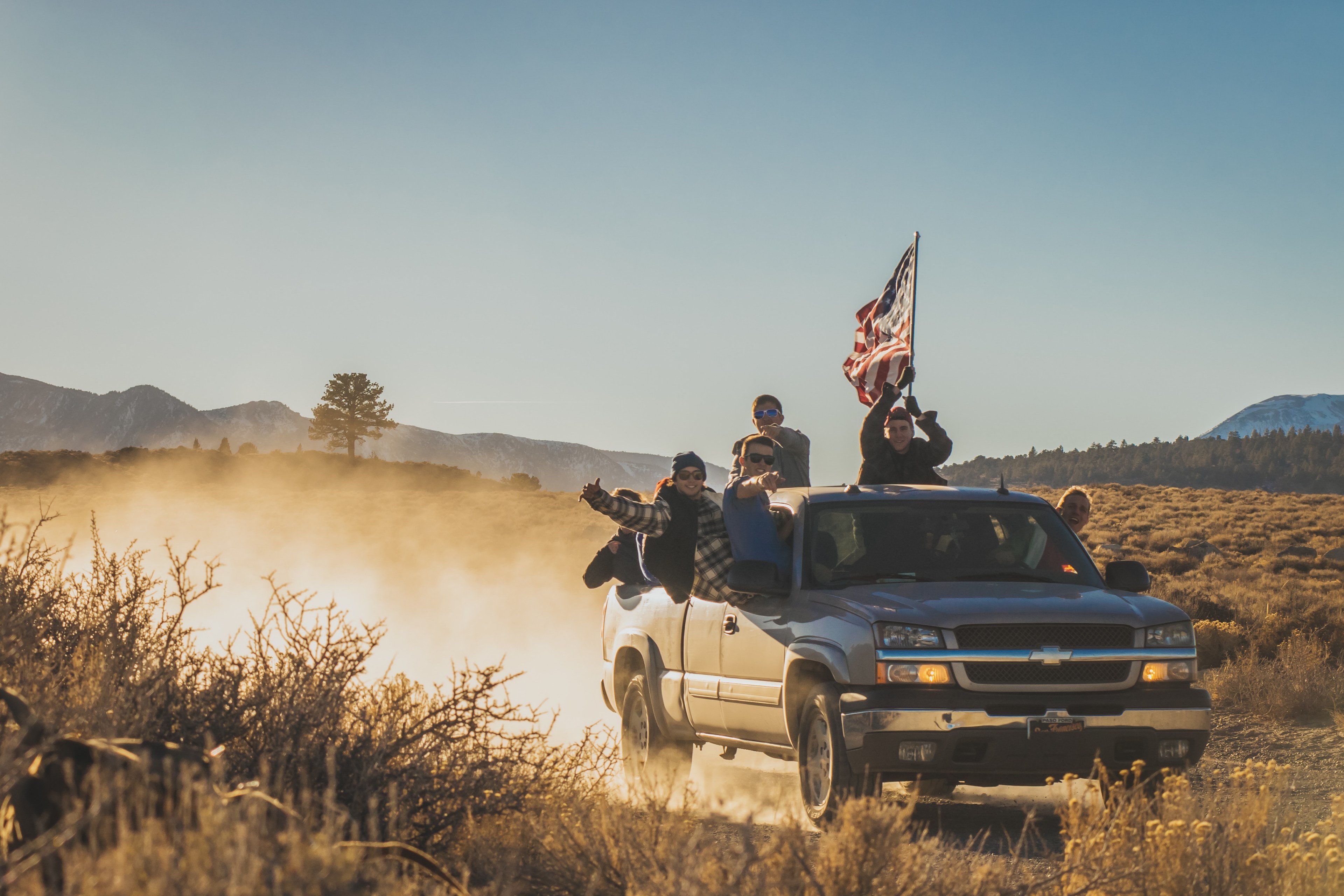 group of guys riding in a chevrolet through a dirt road in mammoth lakes holding up an american flag, mammoth lakes drives 4k, HD Wallpaper
