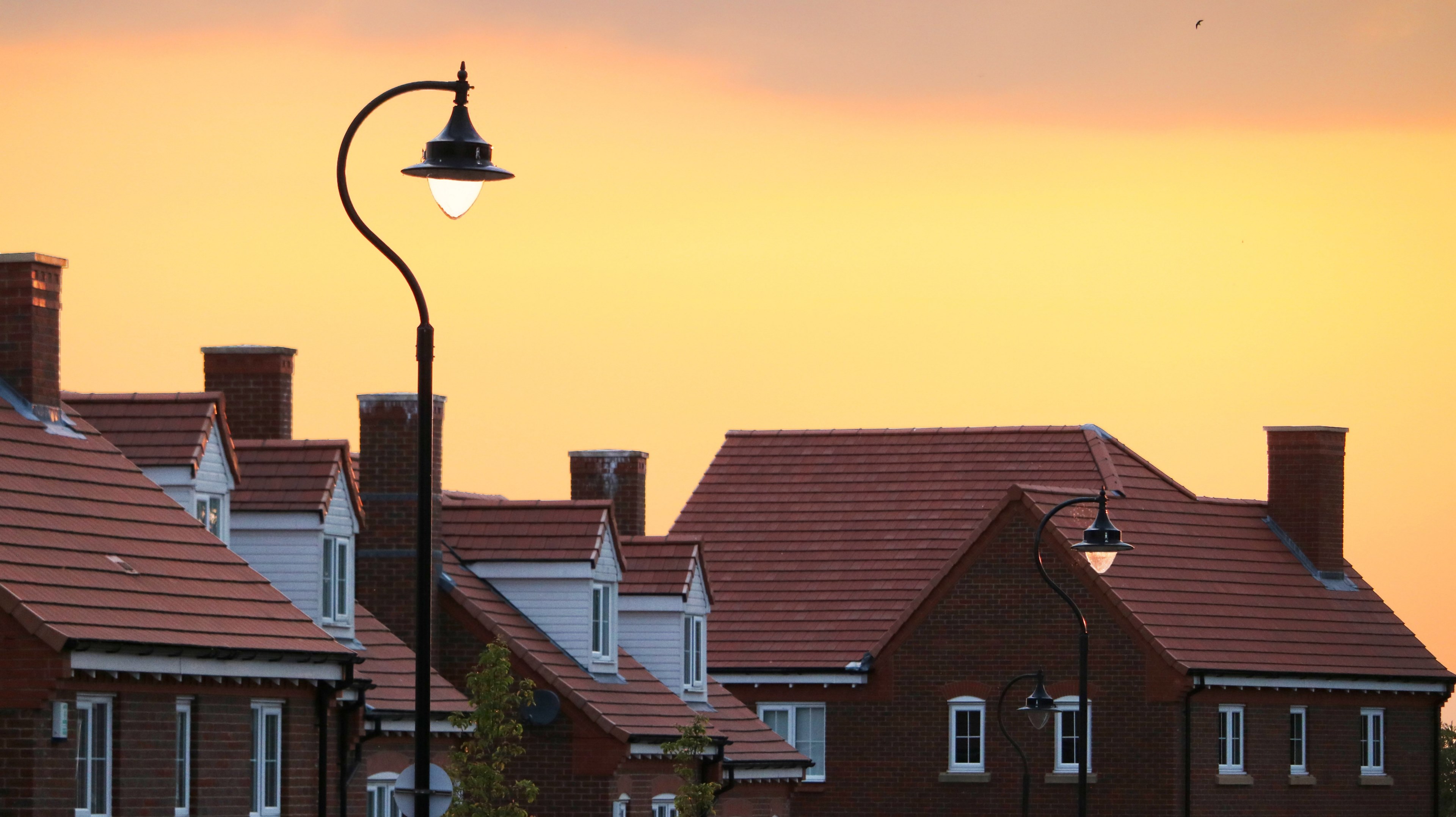 sun setting over red roofed village houses behind street lamp, sun setting on village 4k, HD Wallpaper