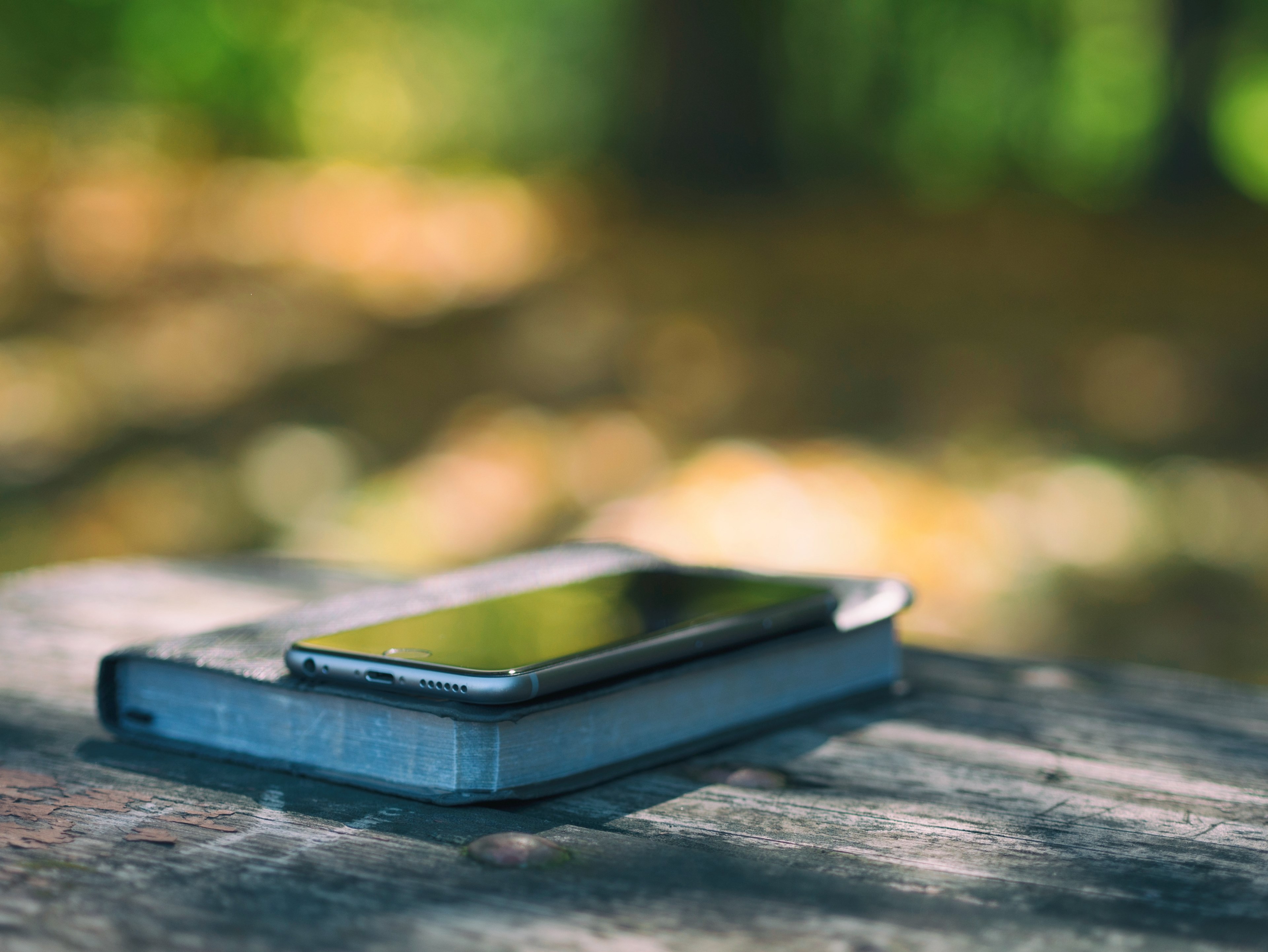 an iphone on top of a book on a worn out wooden surface, iphone on top of a book 4k, HD Wallpaper