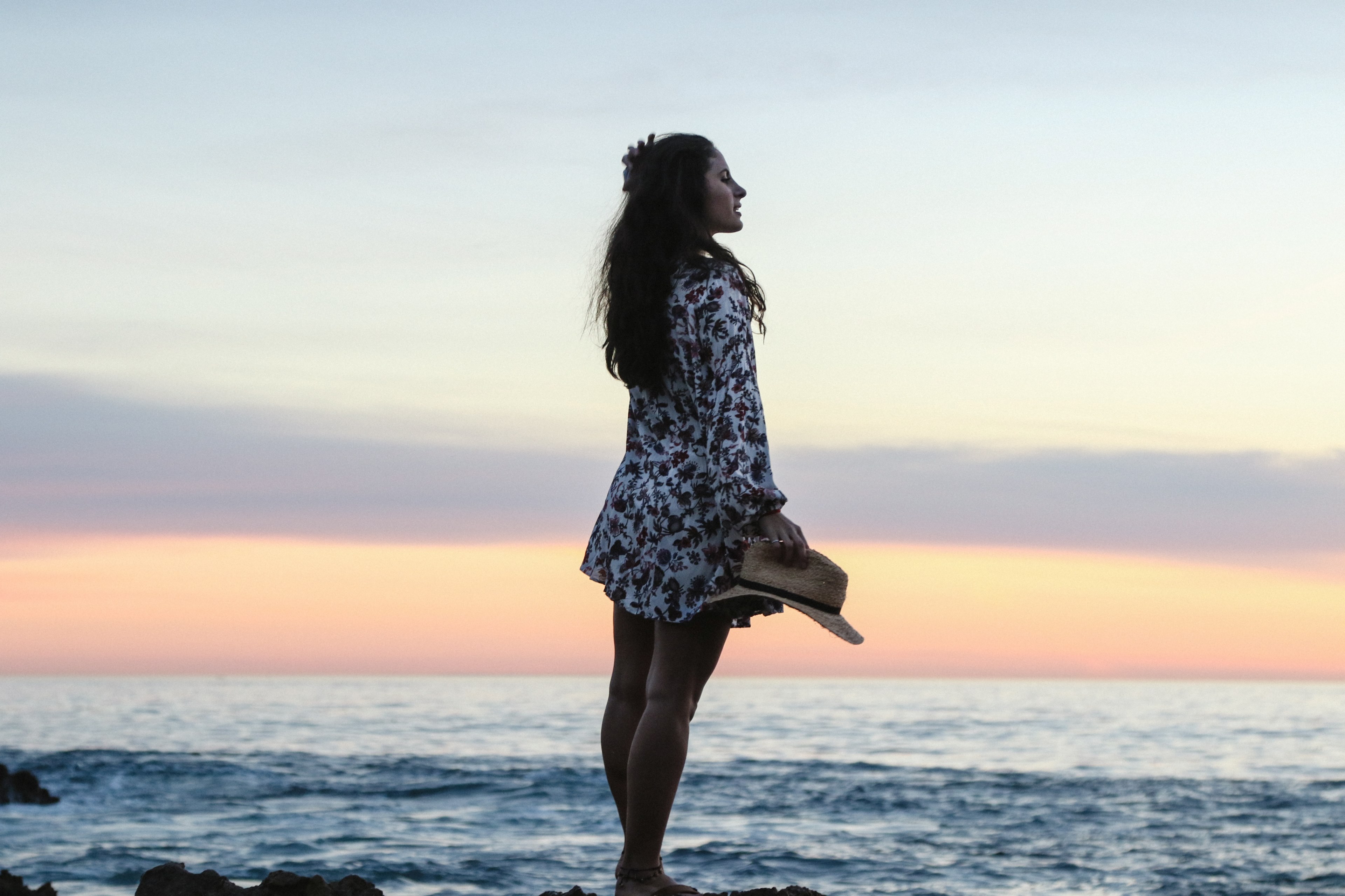 woman in floral shirt holding a hat posing on newport beach rock coastline, woman in shirt posing 4k, HD Wallpaper