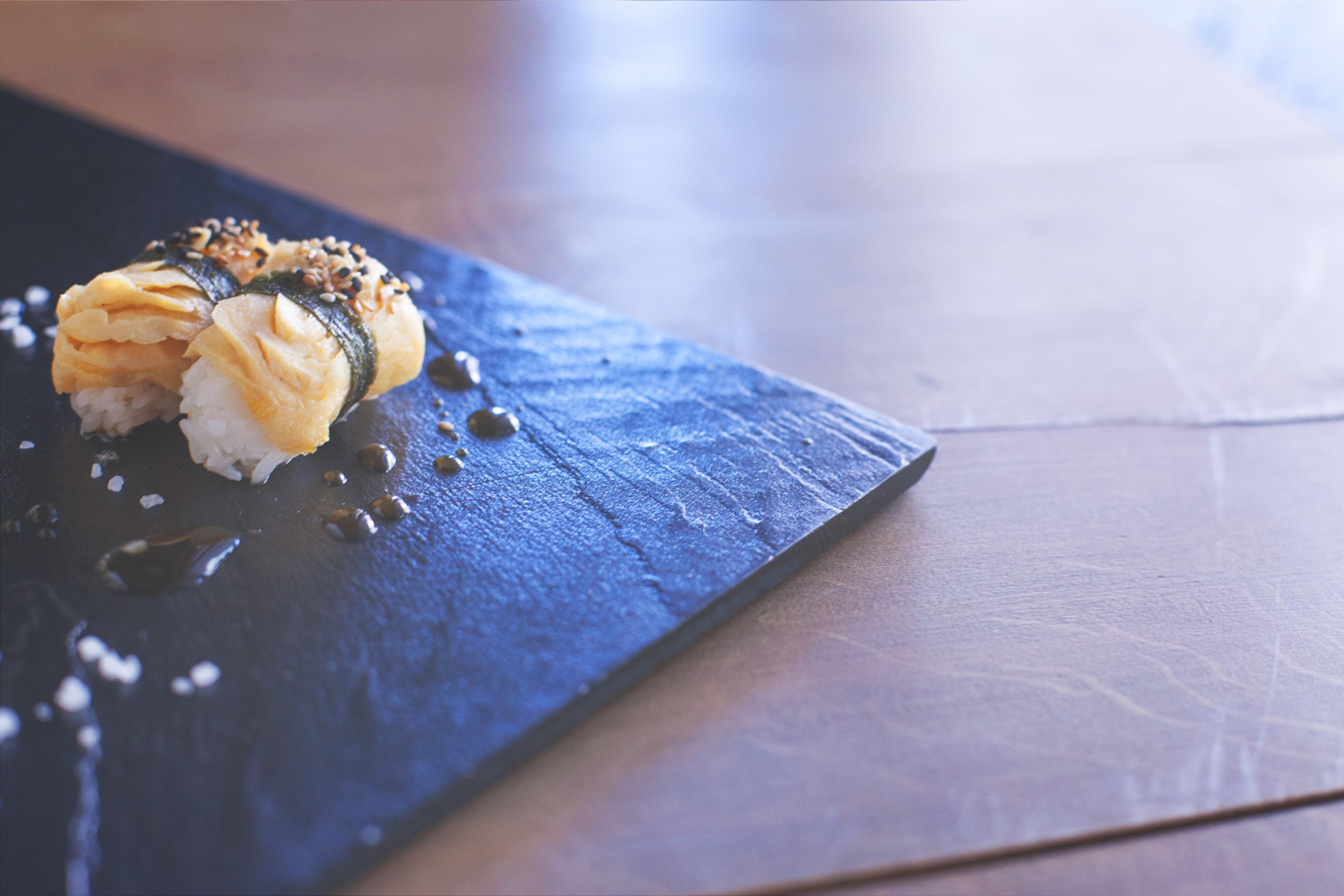 a close up of a set of salmon sushi on a stone plate drizzled with sauce, _sashimi rolls 4k, HD Wallpaper