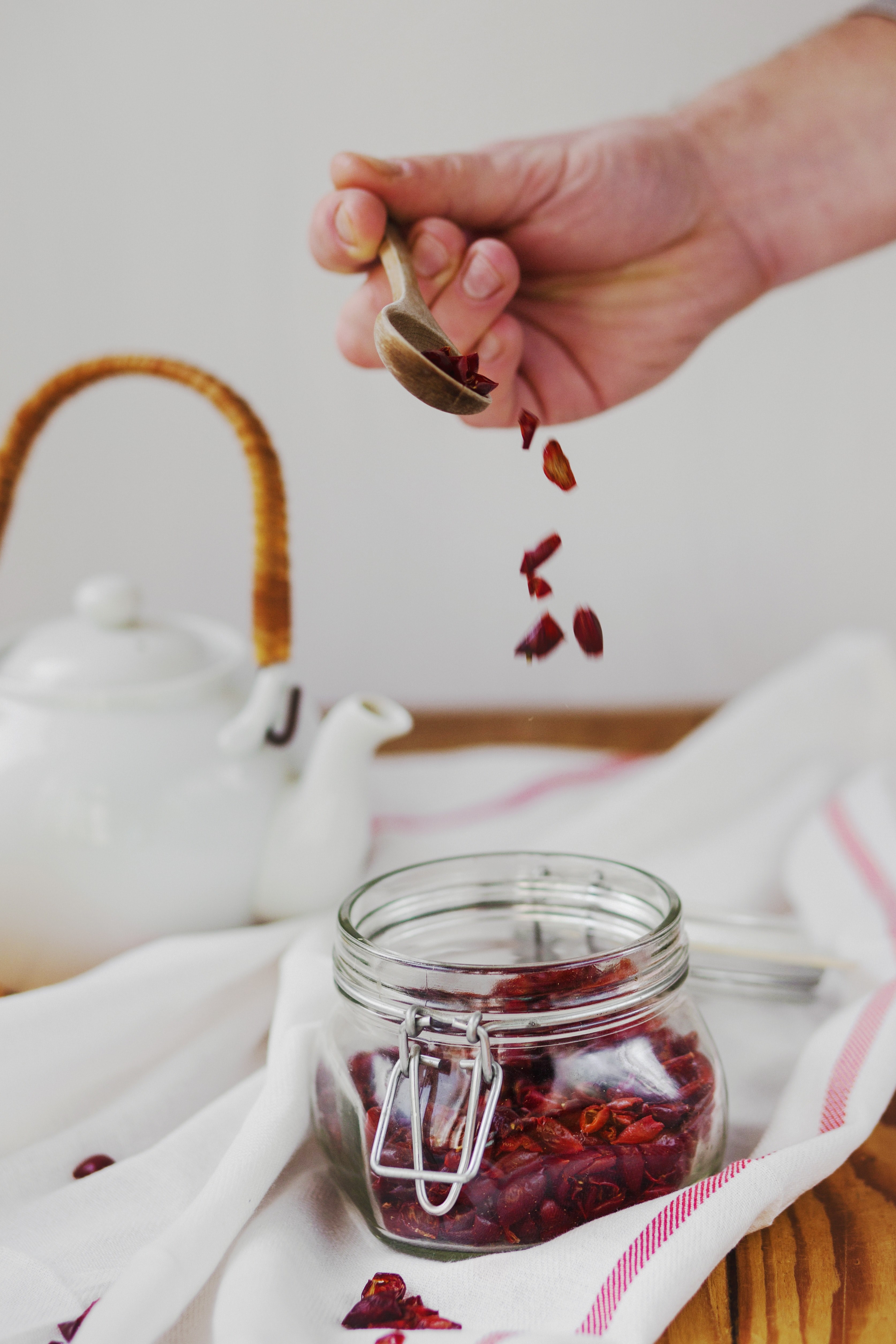 a person scooping out loose leaf tea to brew in a teapot, making rosehip tea 4k, Phone HD Wallpaper