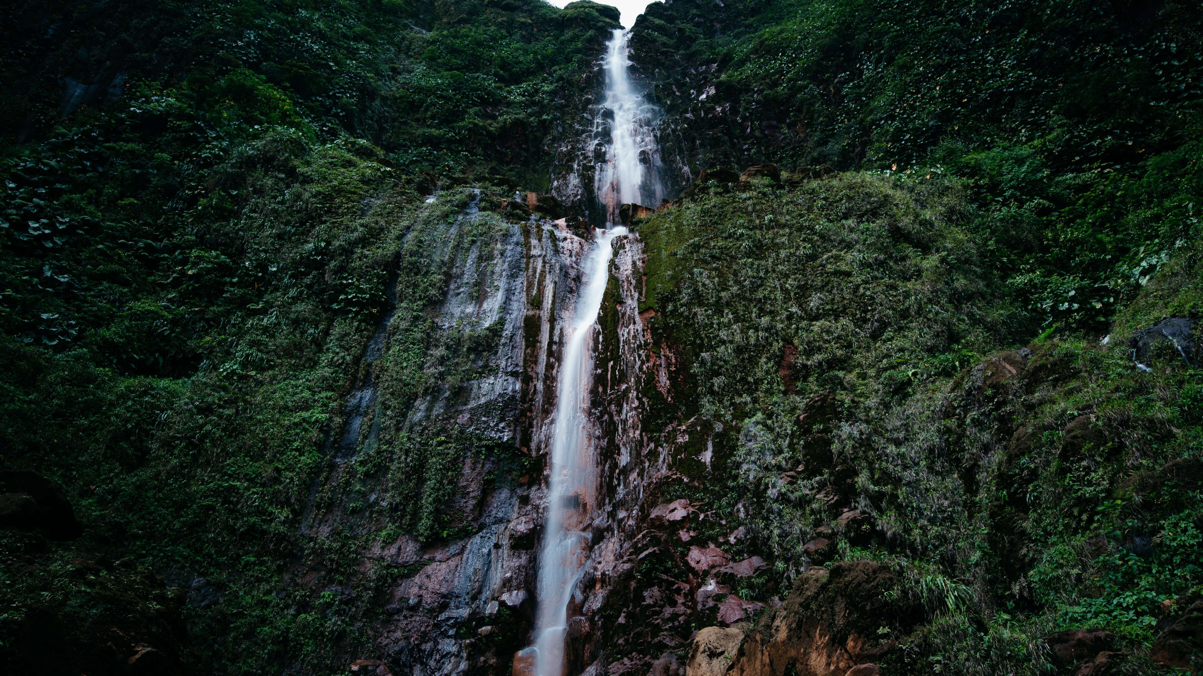 a tall waterfall flowing down a tall rock face covered in green vegetation, wild 4k, HD Wallpaper