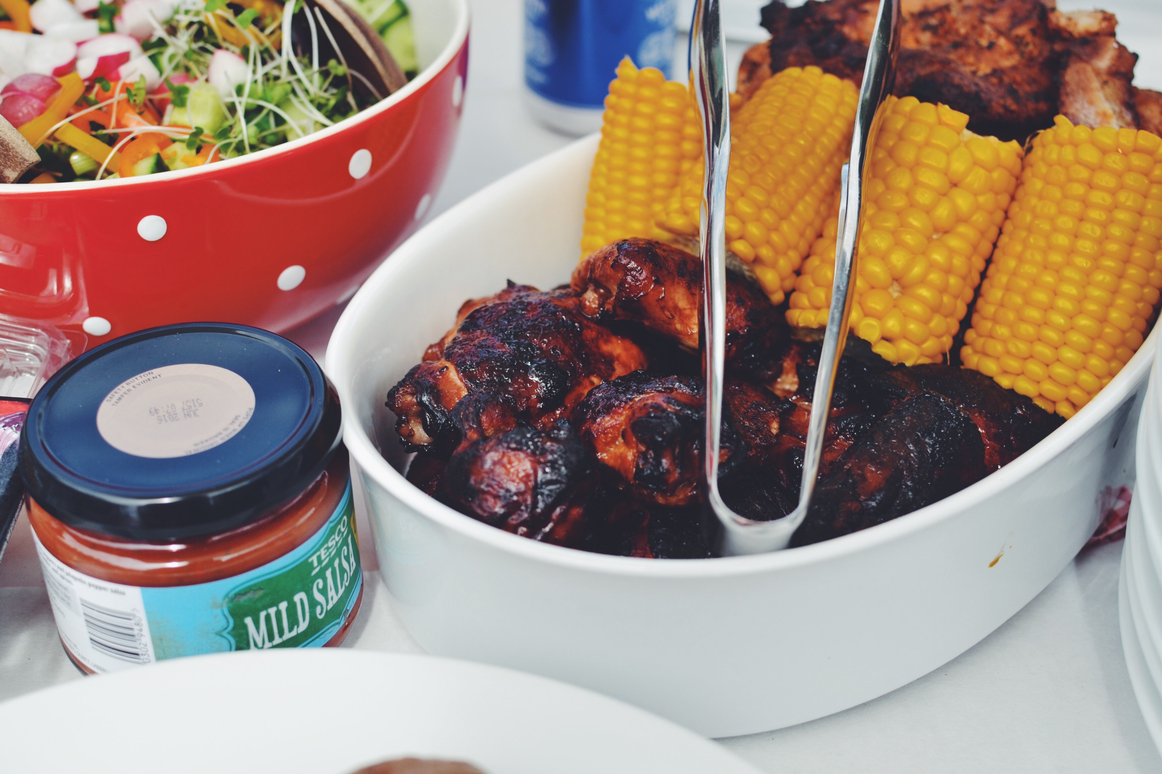 a salad in a polka dotted bowl corn bbq chicken and salsa on a table, family cook out 4k, HD Wallpaper