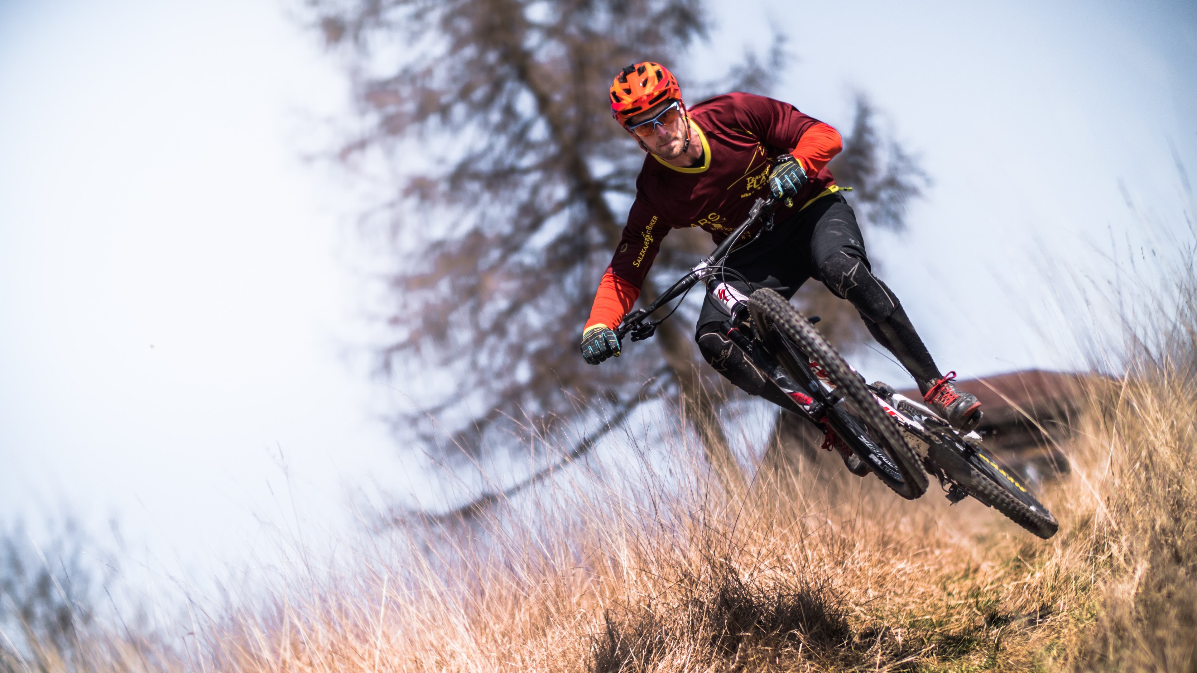 a man wearing an orange helmet riding a mountain bike in hundsham, stunt man 4k, HD Wallpaper