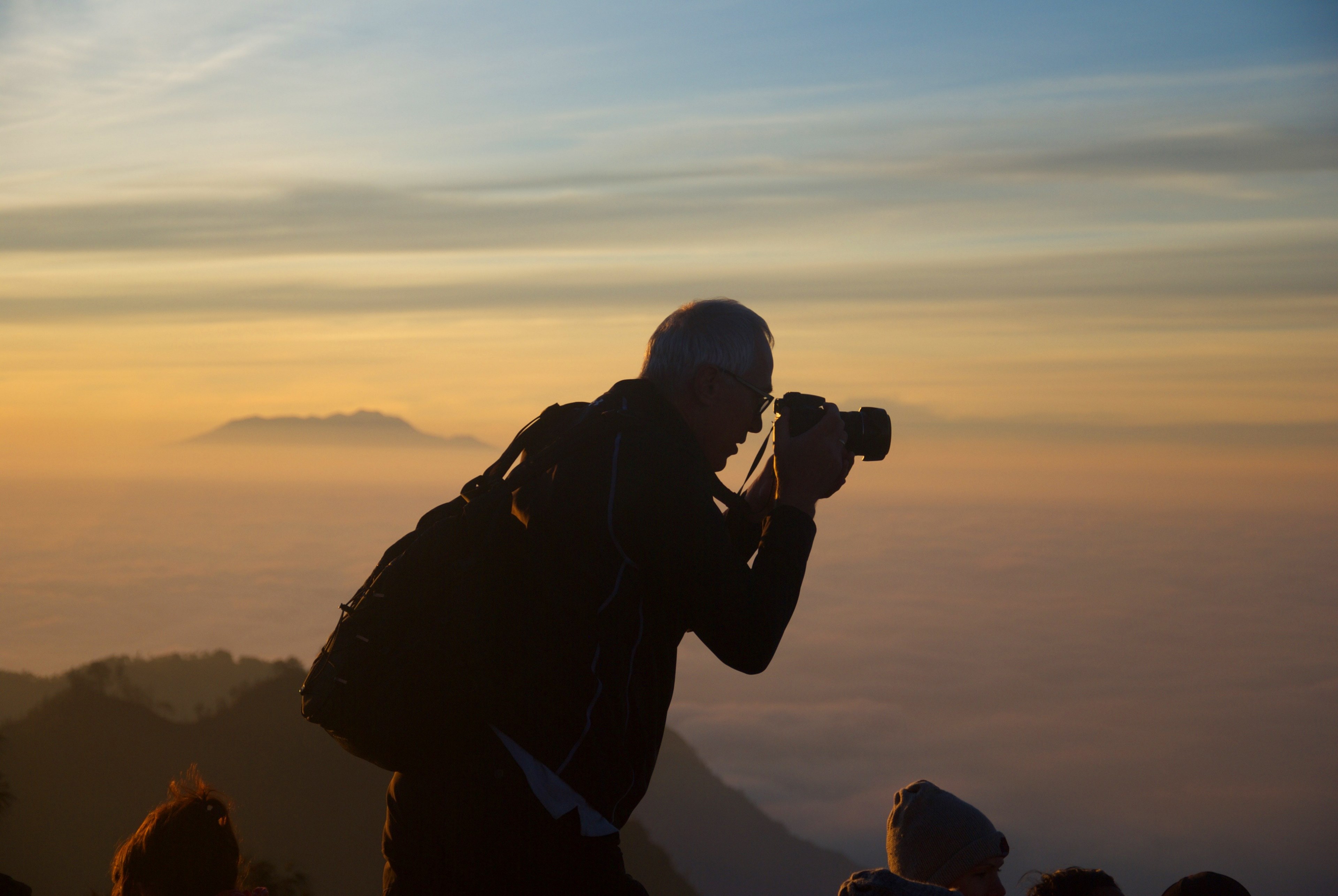 a silhouette of a man taking a photo while on top of a mountain, mountaintop photo 4k, HD Wallpaper